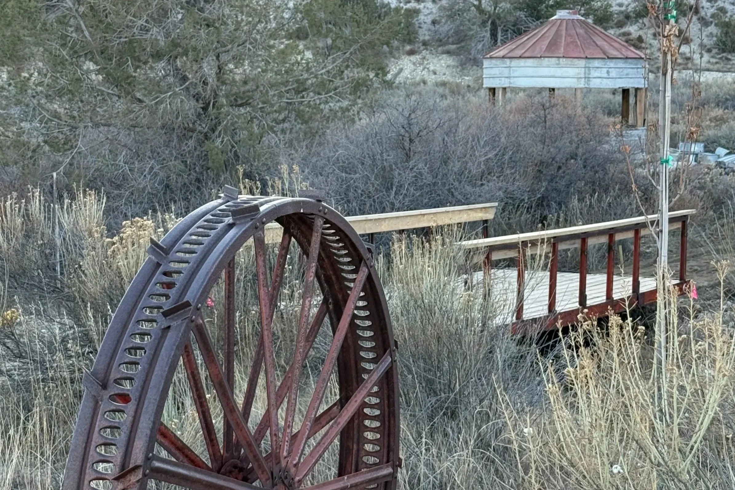 Rustic silod, wagon wheel and bridge over the waterfall at Lost Pond wedding venue near Pueblo, Colorado