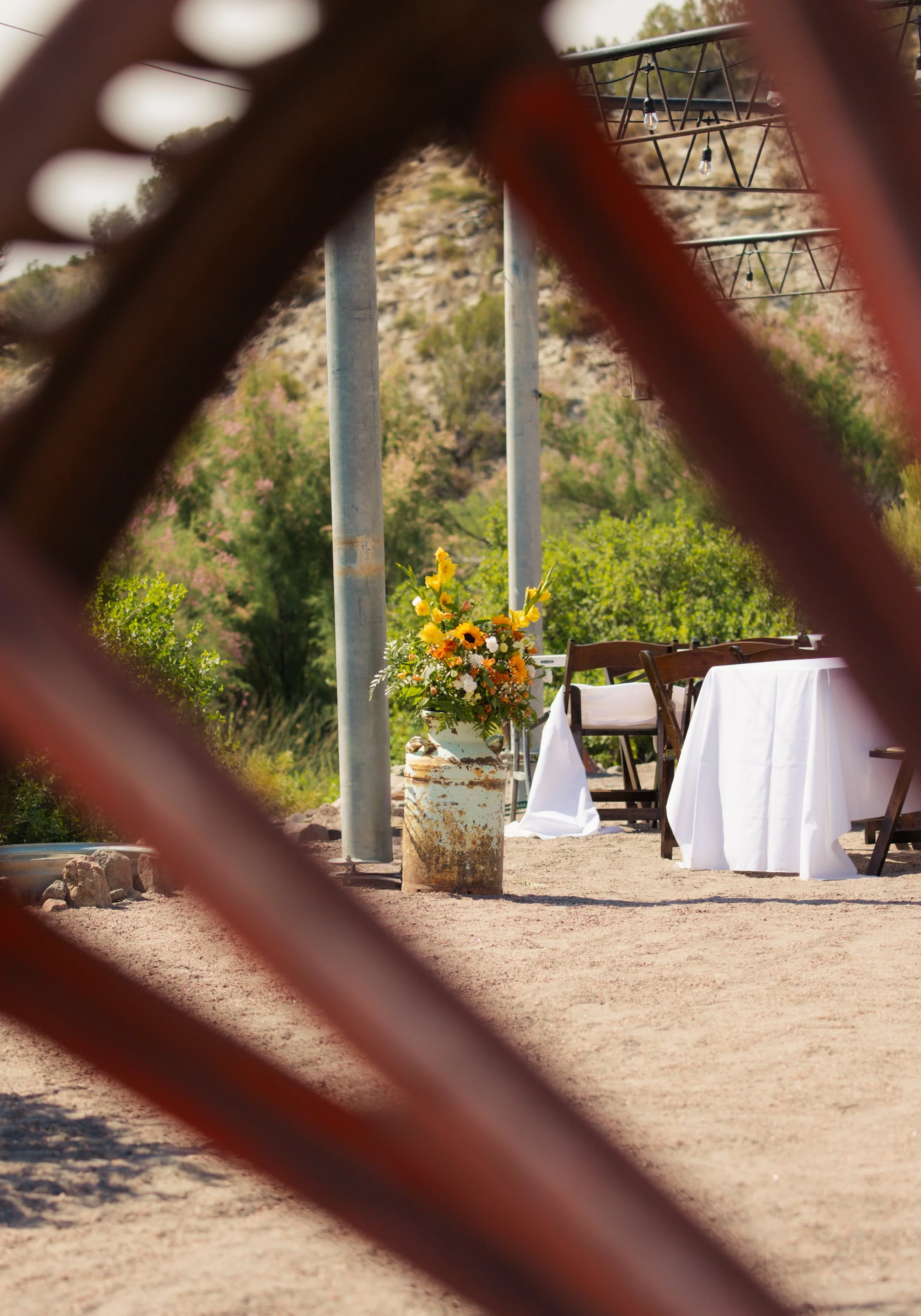 Wedding set up at Lost Pond wedding venue as taken through the vintage wagon wheel. Lost Pond is a rustic outdoor wedding venue in Southern Colorado.