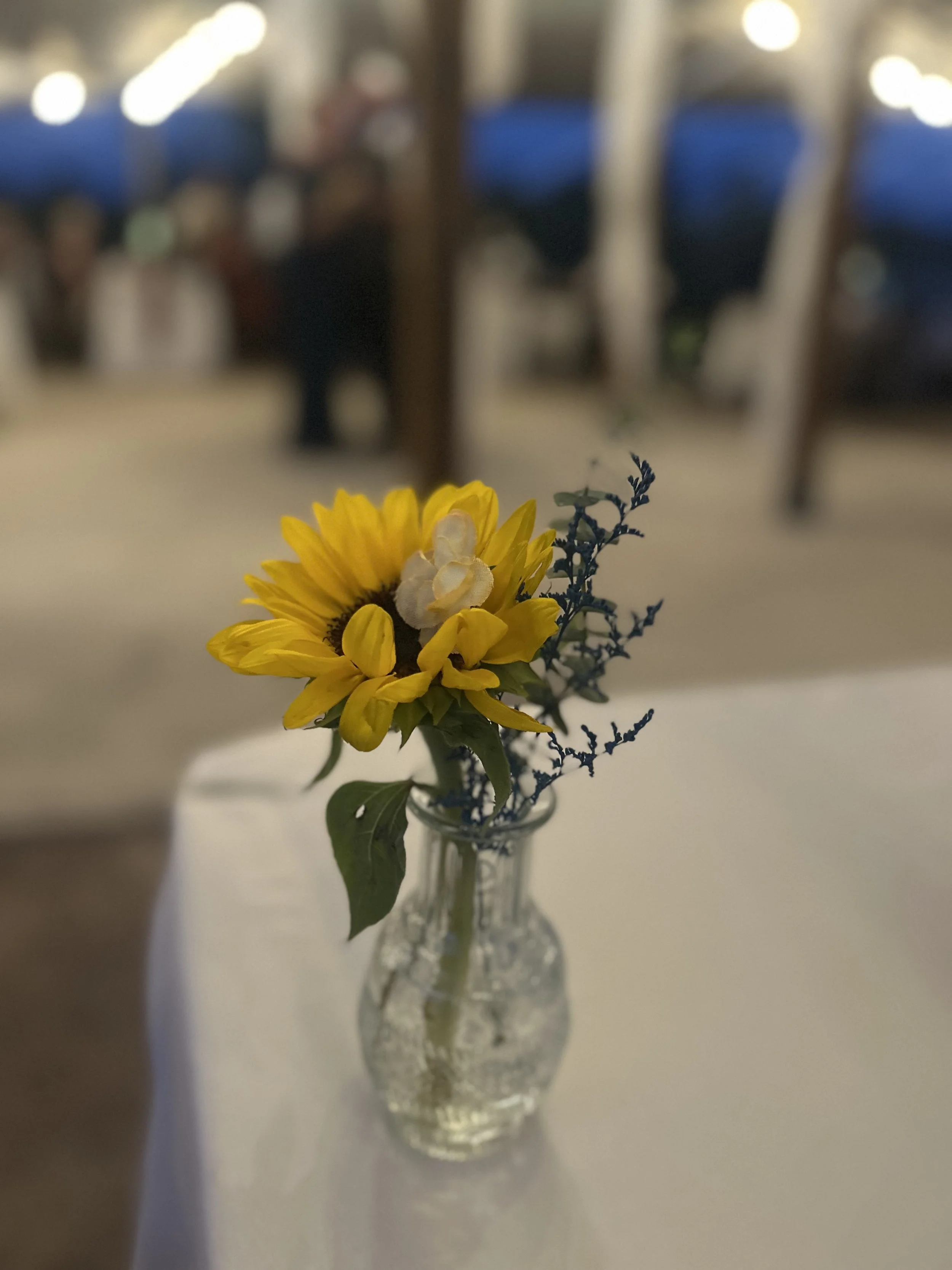 Bud vases at a wedding reception with yellow flowers at Lost Pond wedding venue near Florence, Colorado.