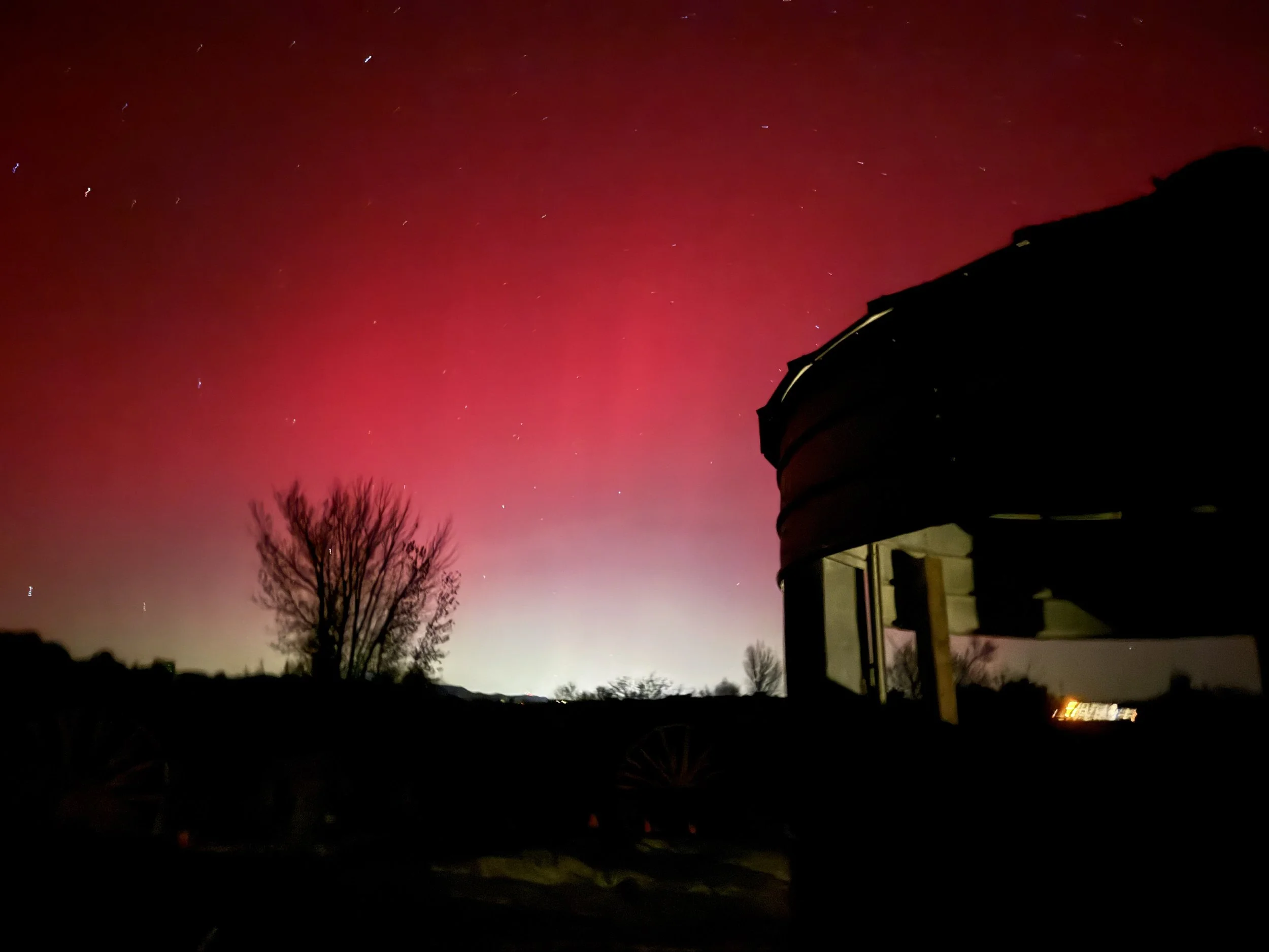 Northern lights behind rustic grain silo at Lost Pond outdoor wedding venue near Canon City Colorado