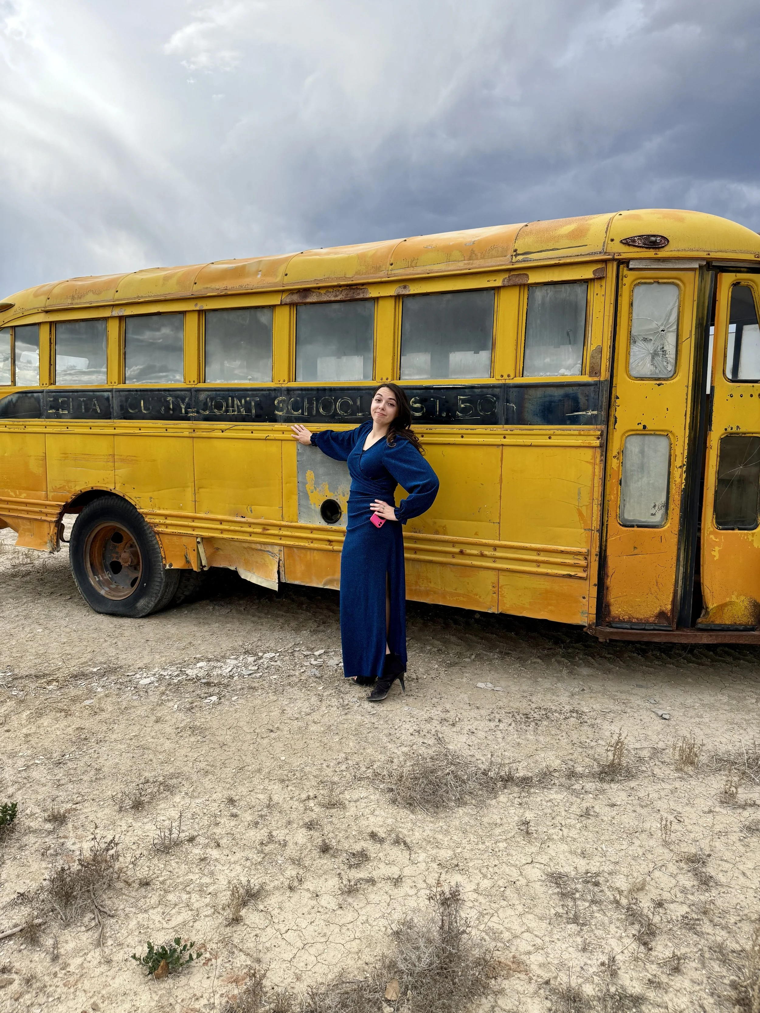 A bride in front of a vintage school bus photo spot at Lost Pond rustic outdoor wedding venue near Canon City Colorado