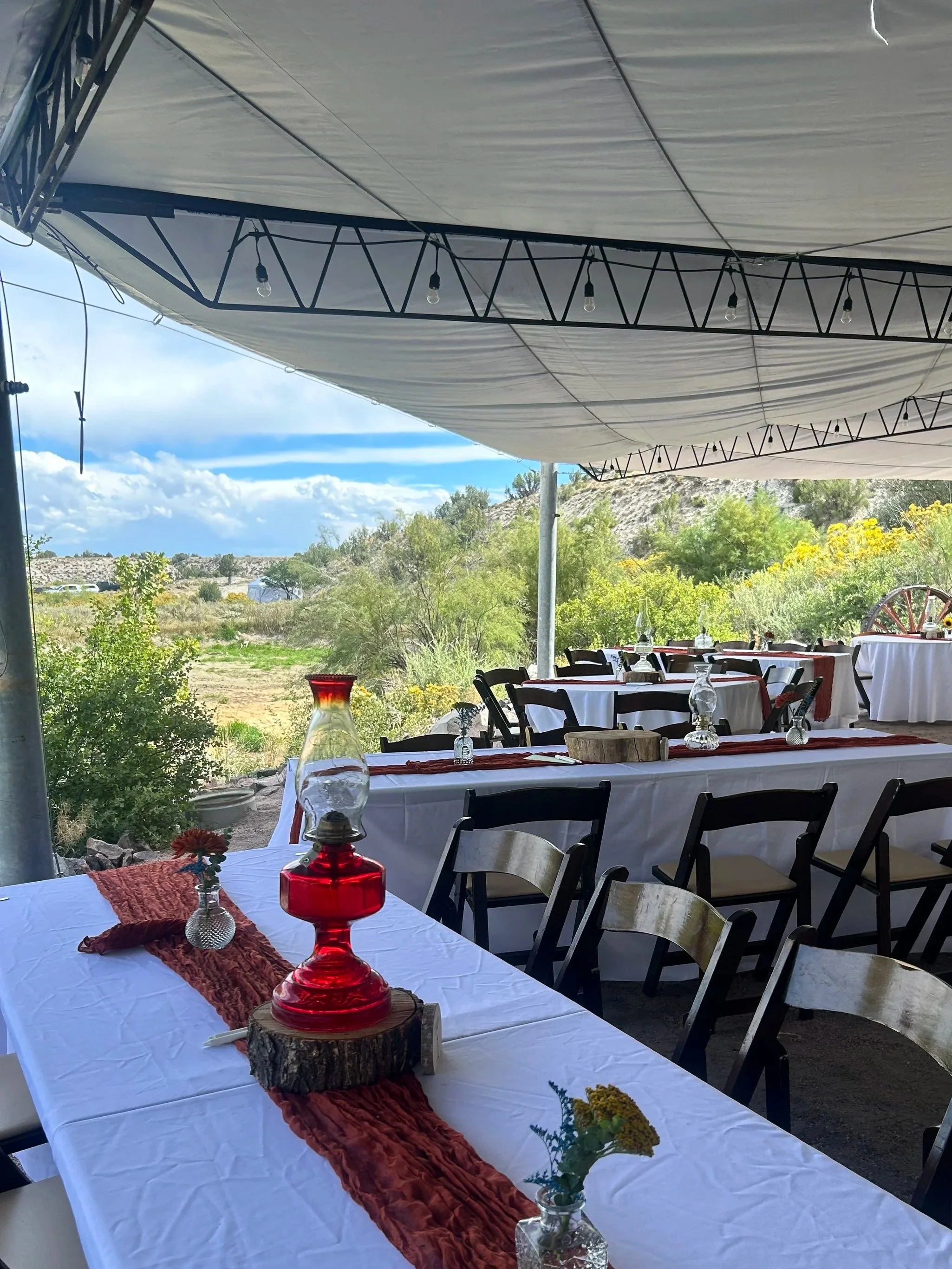 Wedding reception under the tented canopy at the pondside wedding venue Lost Pond near Pueblo, Colorado.