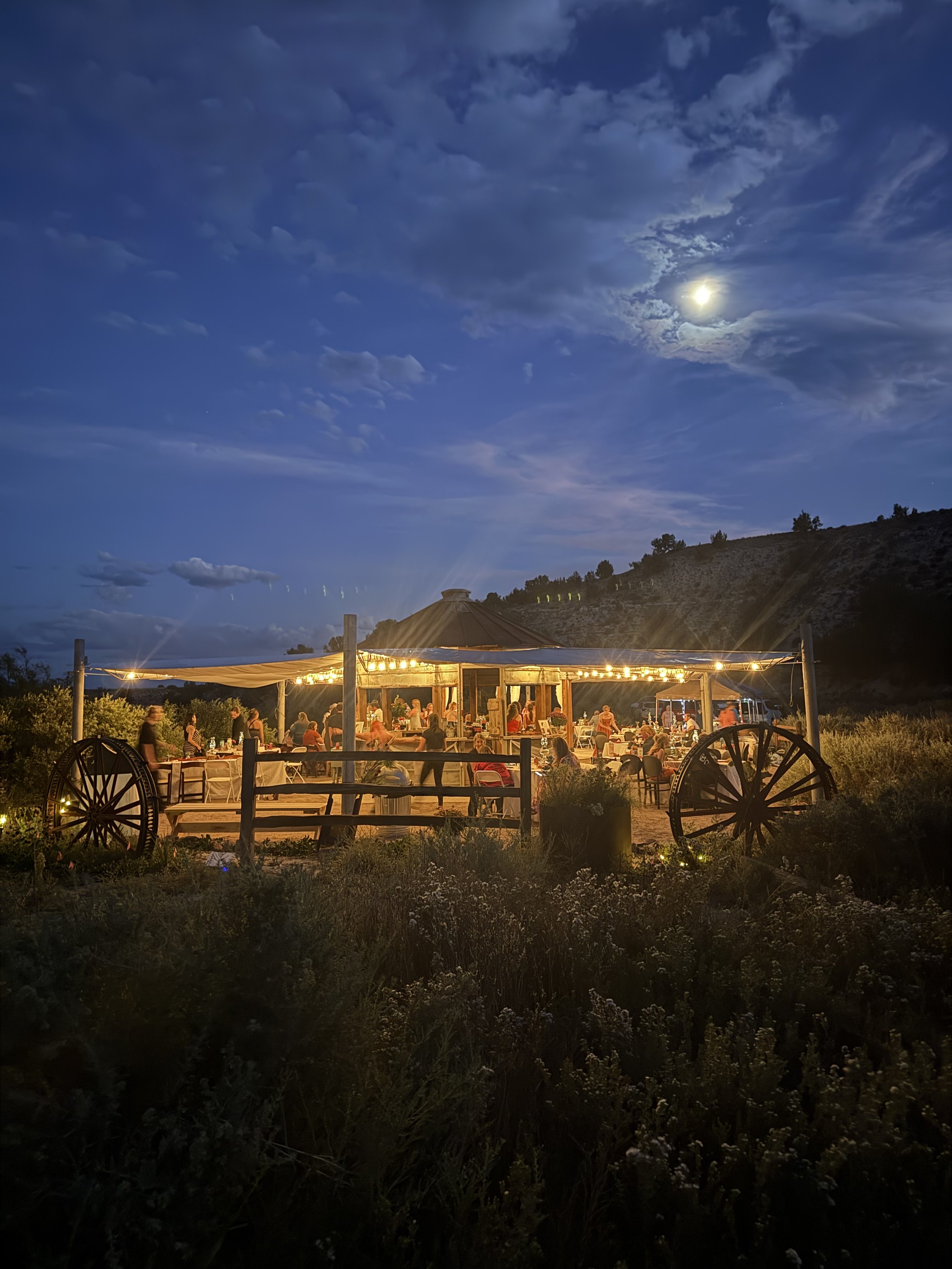 The rustic silos at Lost Pond wedding venue with the tented canopy and the wagon wheels beside the pond near Florence, Colorado.