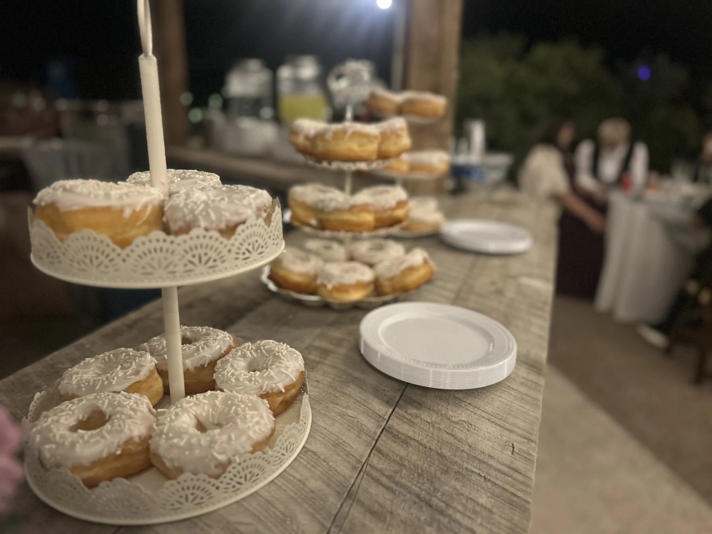 Wedding donuts on the rustic barnboard bar at a wedding reception at Lost Pond wedding venue near Florence, Colorado.