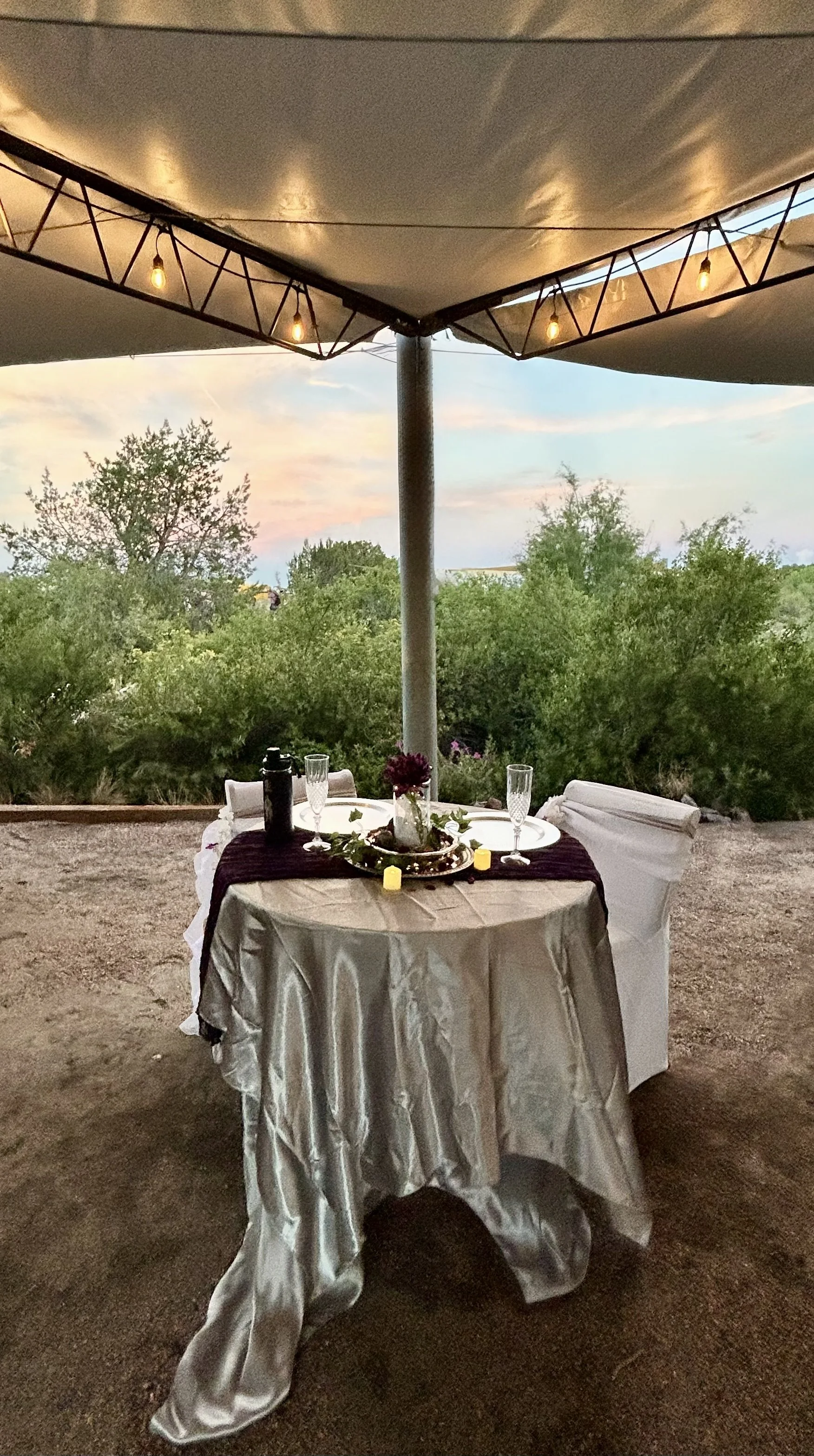 Sweetheart table set for wedding reception under the tented awning at outdoor wedding venue Lost Pond between Colorado Springs and Canon City, Colorado.