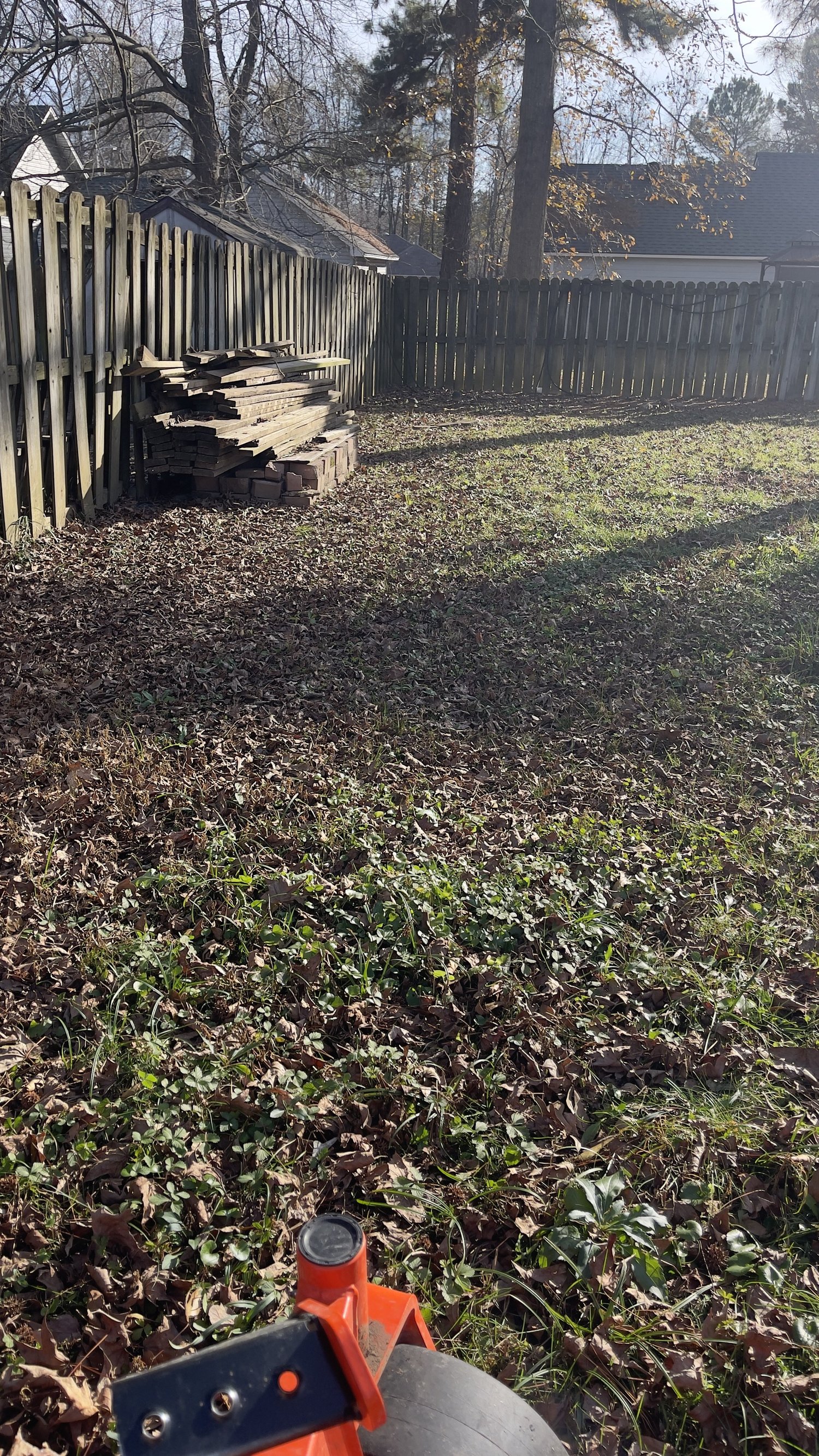 Backyard in Cabot, Arkansas covered in a thick layer of fallen leaves before a December fall cleanup by White River Lawn Co.