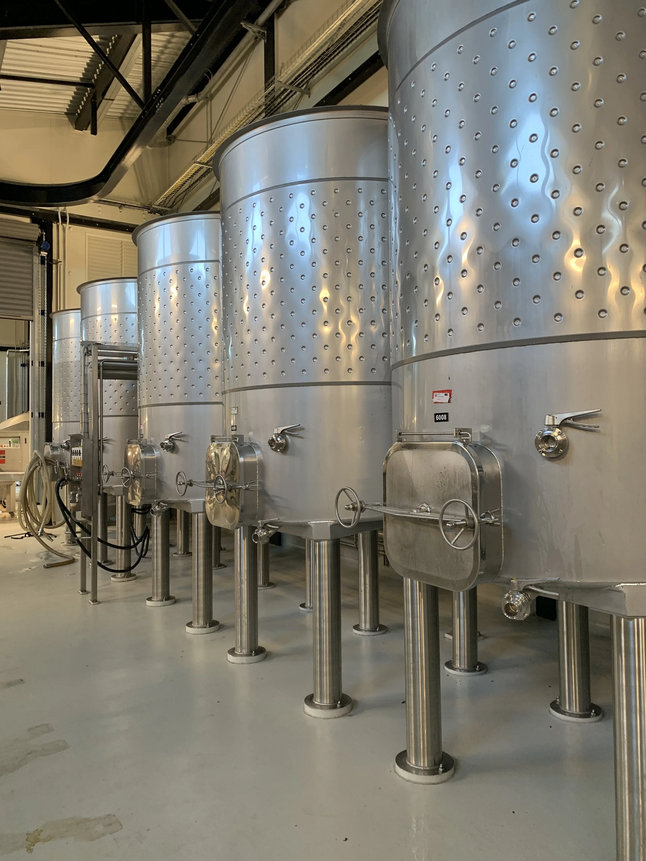 Industrial stainless steel tanks in a manufacturing facility.