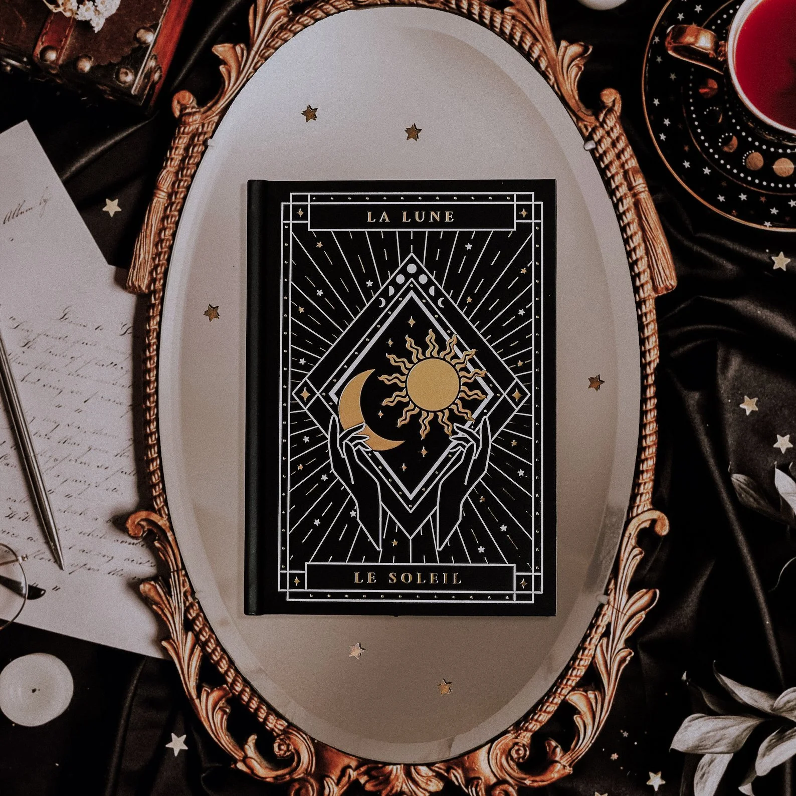 A5-sized hardcover journal featuring intricate gold foil sun and moon designs on a black cover. Available with dotted, lined, blank, or black pages, this celestial-themed notebook is ideal for journaling, sketching, or planning under the stars.