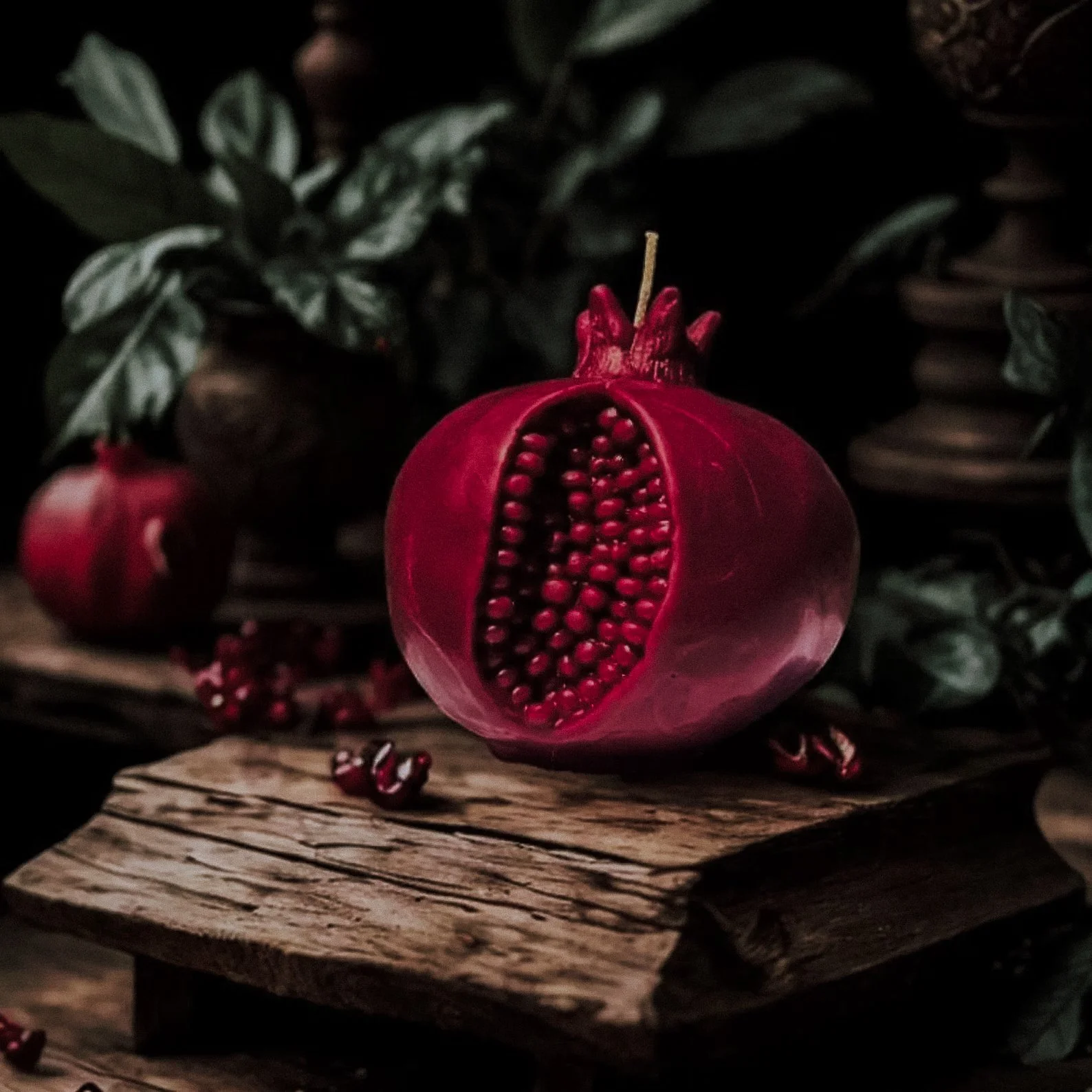A handcrafted 4x4-inch beeswax candle dyed in a rich, natural red hue to resemble a pomegranate, complete with detailed seeds and a realistic texture. Inspired by the myth of Persephone, this candle symbolizes transformation and rebirth, making it a