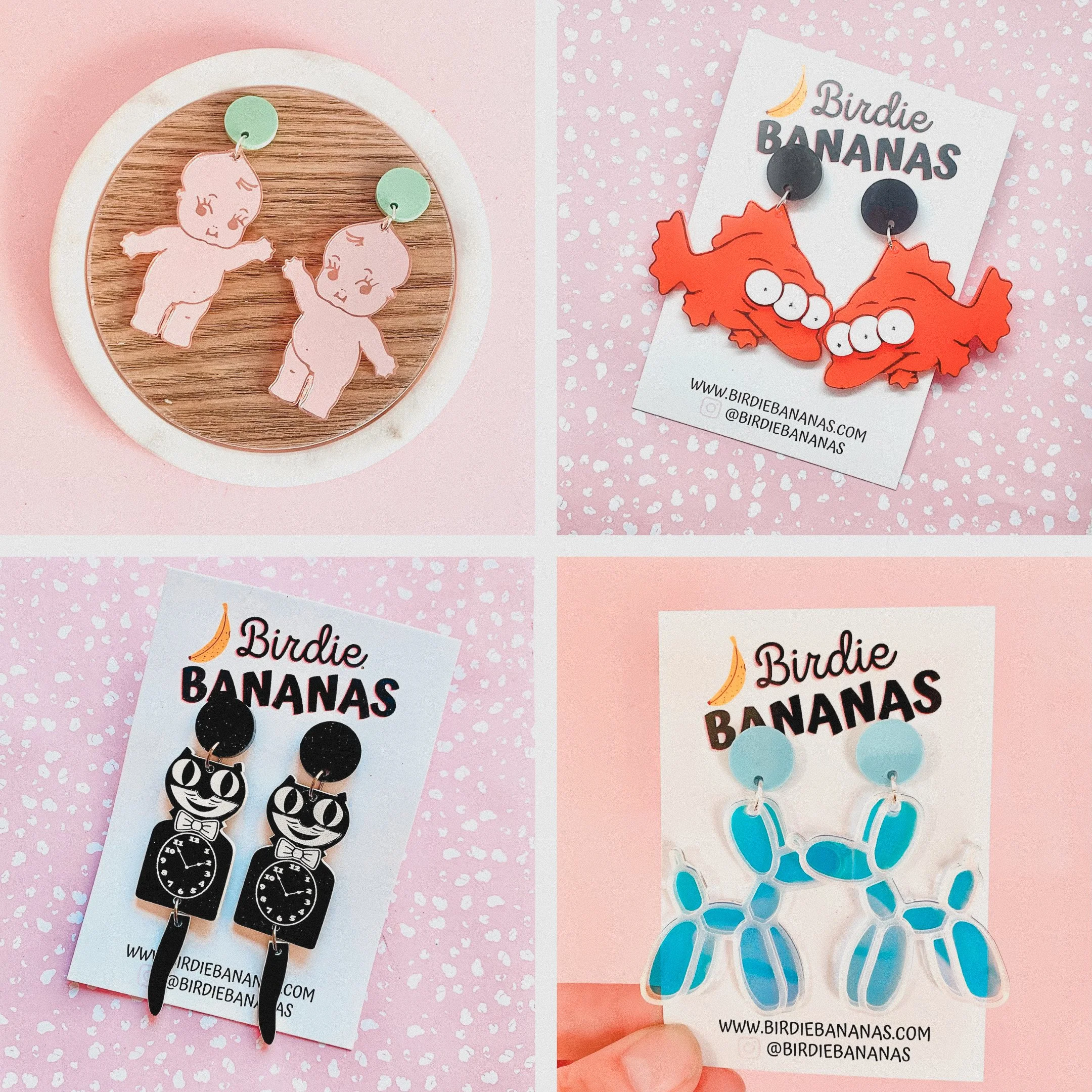 Collage of four images showing different pairs of colorful earrings on pink and white patterned backgrounds. Top left features pink Baby doll earrings with green backing, top right has orange Birdie Bananas earrings with black backing, bottom left shows black cat-themed earrings with clock detail on white card, and bottom right has blue and clear sea turtle earrings.