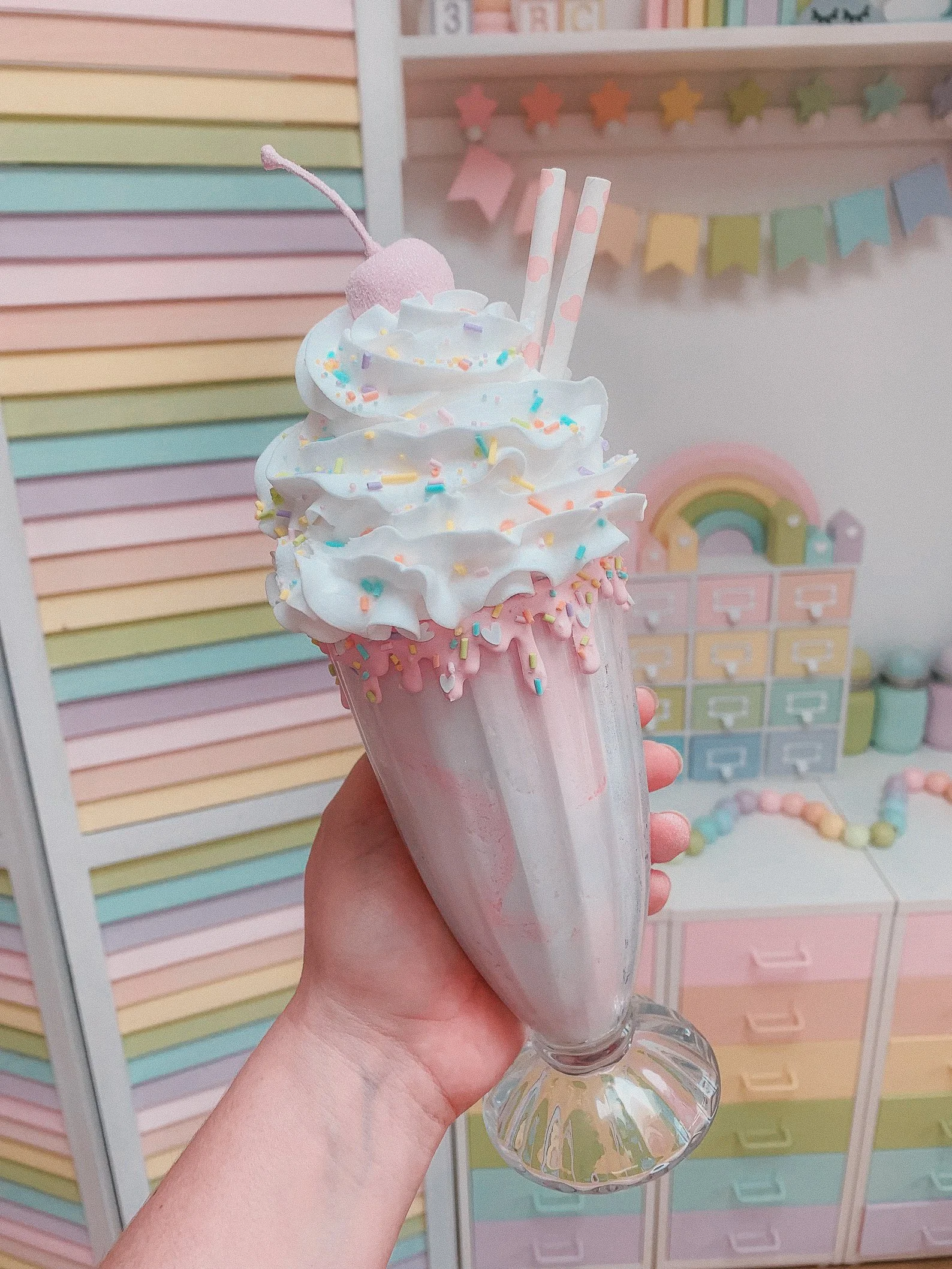 Eye-catching rainbow milkshake prop with whipped topping and straw, perfect for maximalist decor, diner vibes, or food-themed shoots.