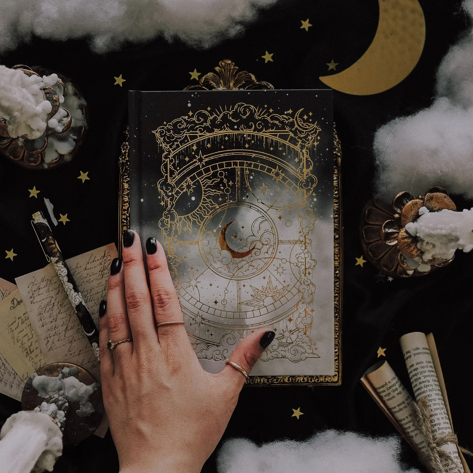 A5-sized hardcover journal featuring intricate gold foil celestial designs on a black cover. Available with dotted, lined, blank, or noir (black) pages, this mystical notebook includes 160–180 pages of high-quality paper, a ribbon placeholder, and gi