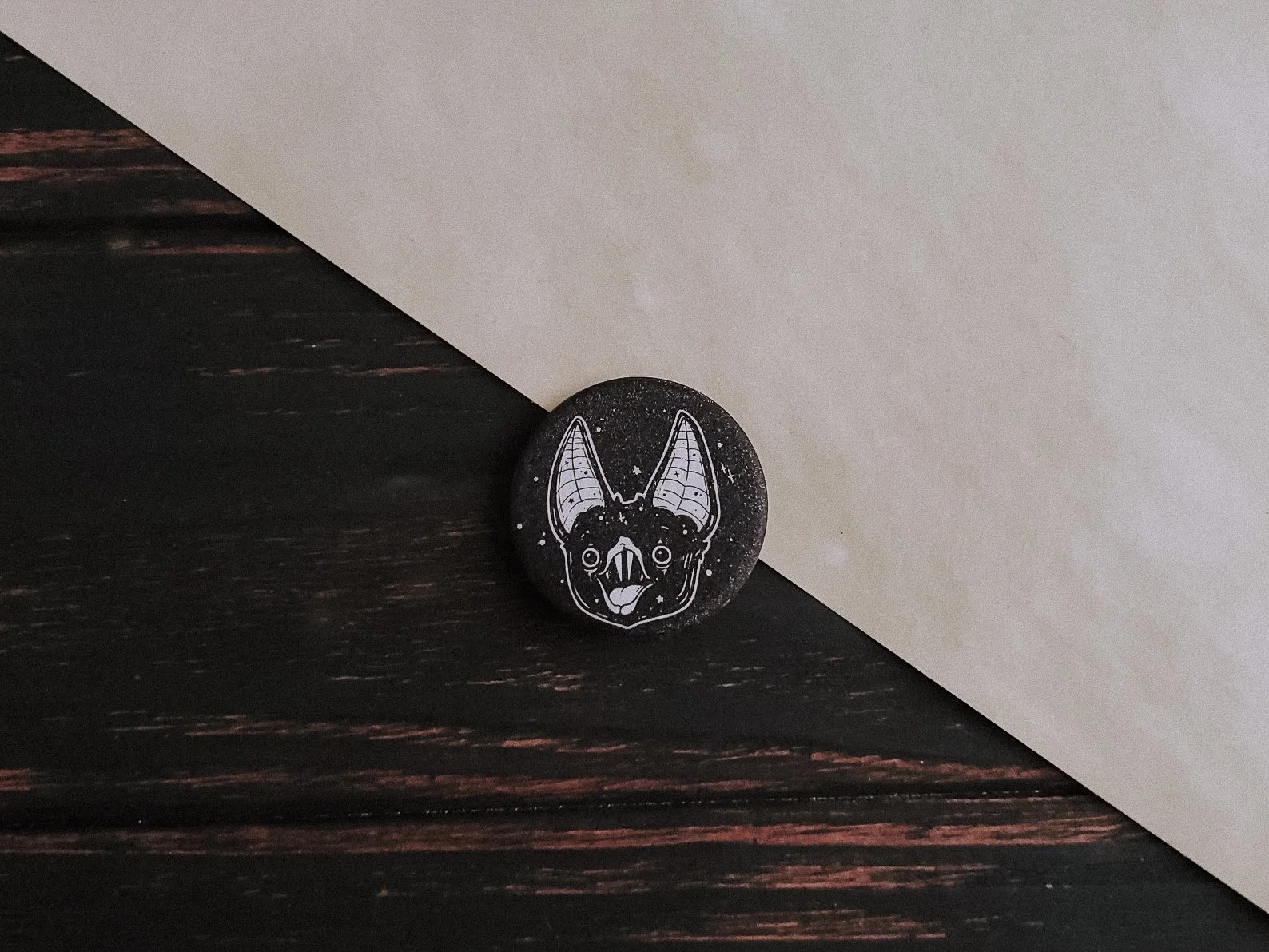 1.5-inch sparkling finish pin featuring a cheerful vampire bat illustration. Ideal for gothic, whimsigoth, and creepy-cute aesthetics, perfect for accessorizing jackets, bags, or witchy planners.
