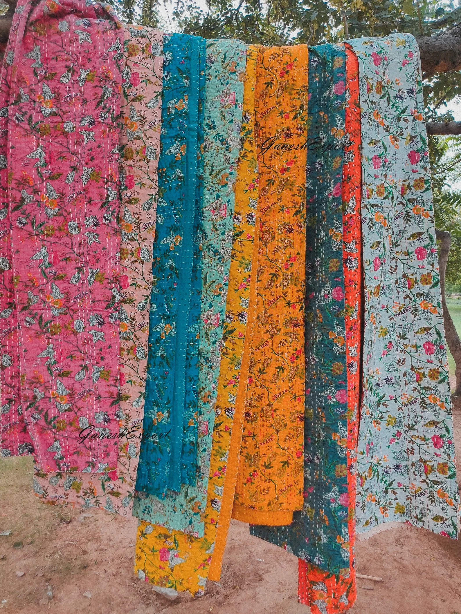 Lightweight cotton quilt made in India with traditional floral block prints, ideal as a breathable bedspread, layering piece, or boho throw.