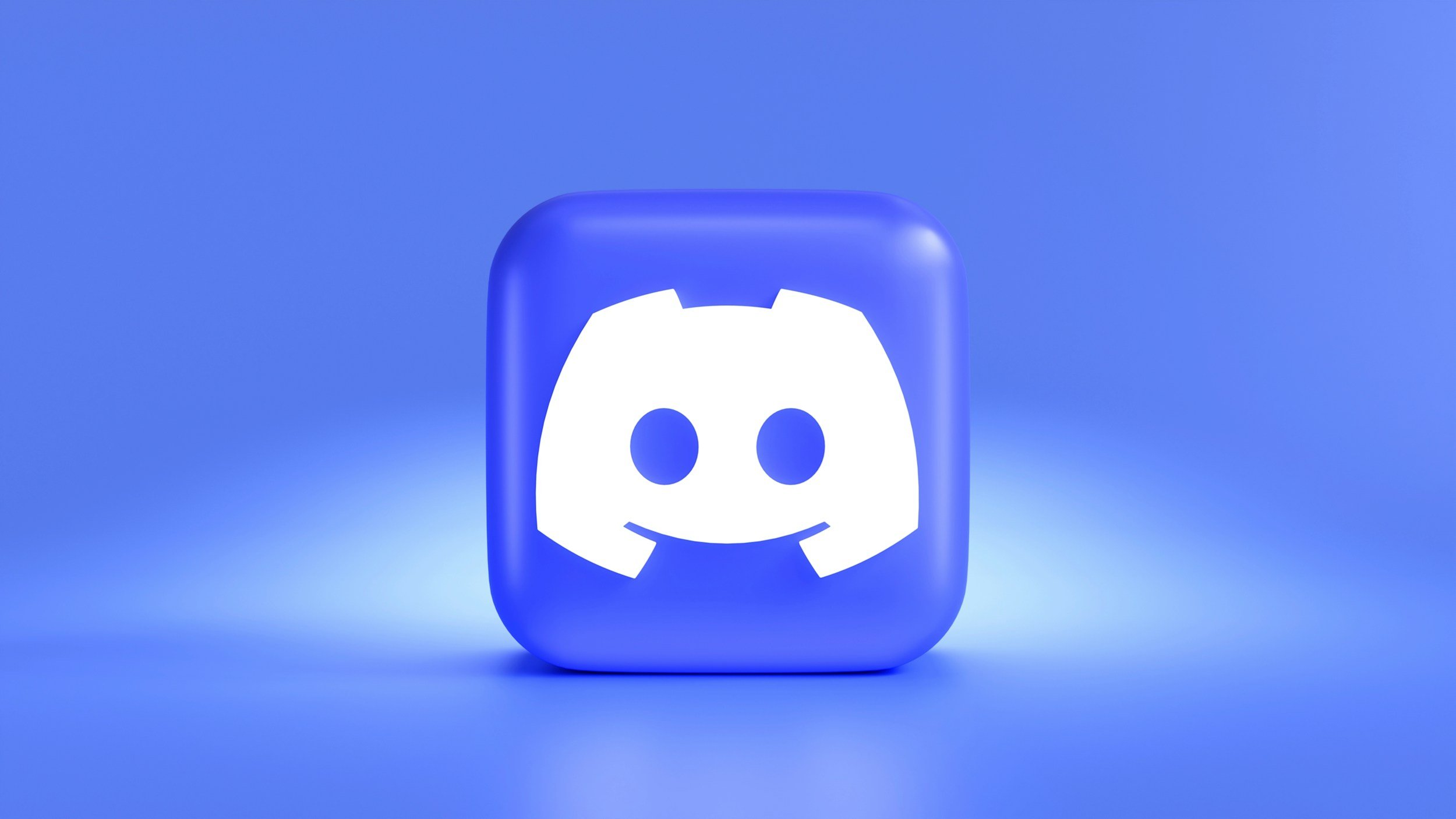 Blue square icon with rounded edges and the white logo of Discord, a smiling game controller face with two circular eyes and a broad smile, centered against a blue background.