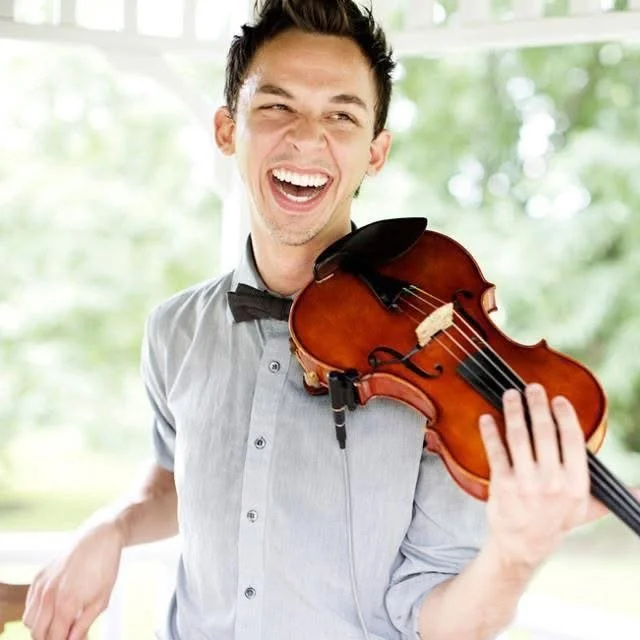 Man smiling and playing a violin