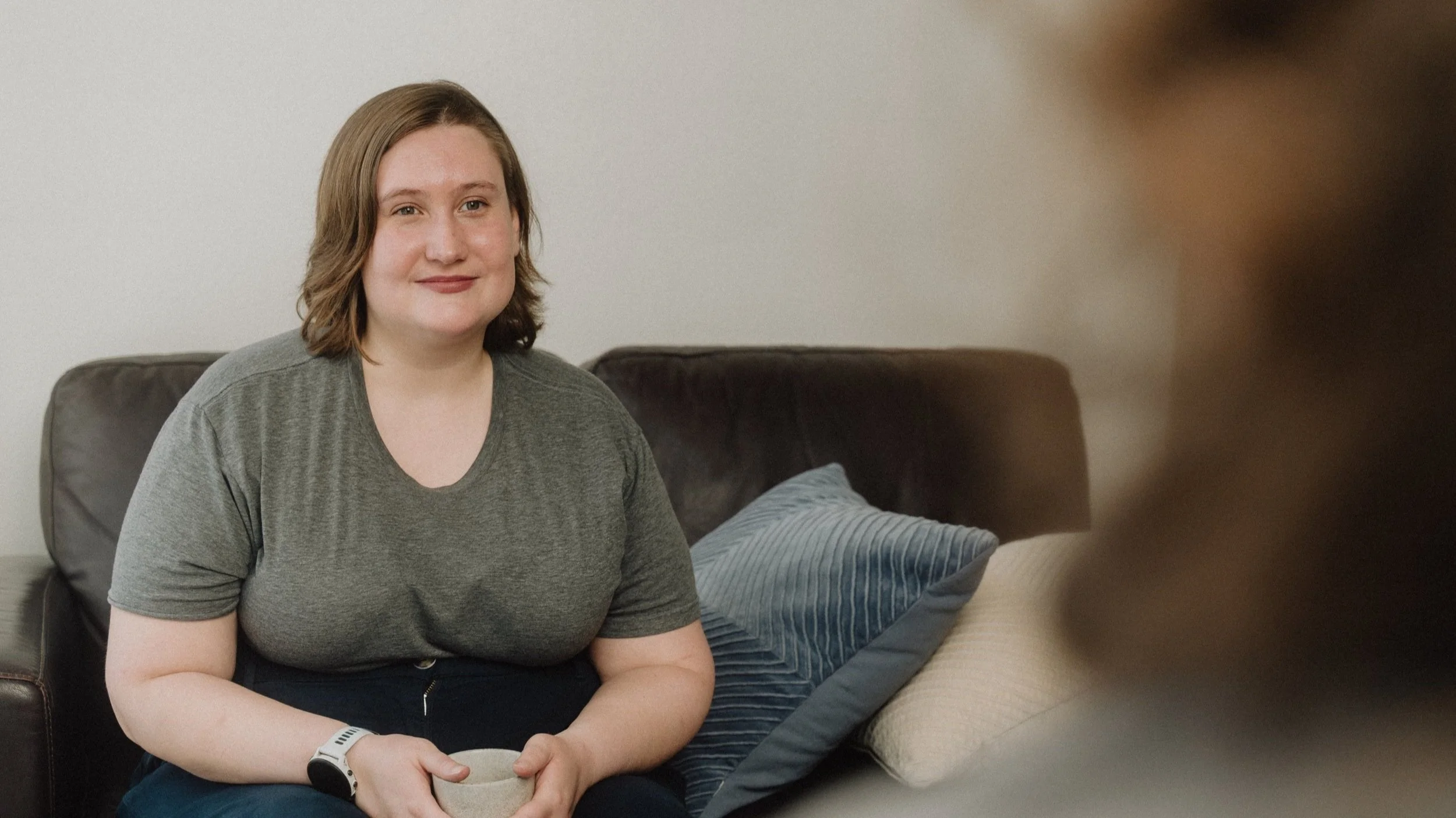 Shayla on Couch With Tea Cup Listening to Client
