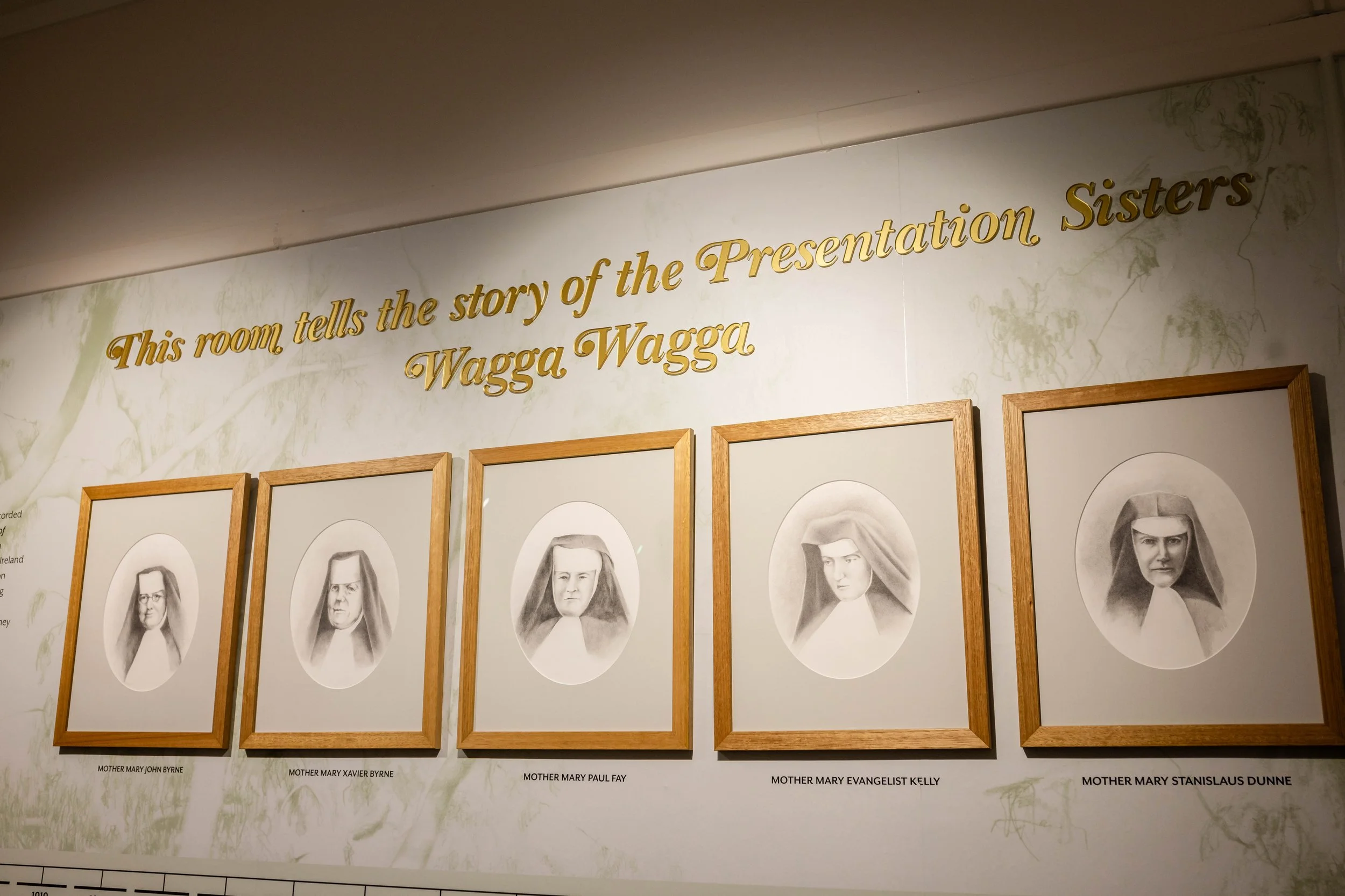 Wall exhibit with sepia portraits of women, labeled with their full names, under a quote about the story of the Presentation Sisters.