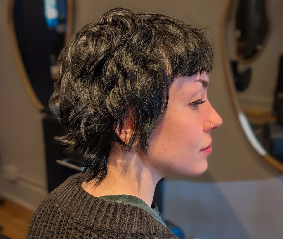 Short hair cut known as a pixie or bixie on curly black hair. this haircut was performed by Frankie at FM Hair and Esthetics in Mission Calgary Alberta