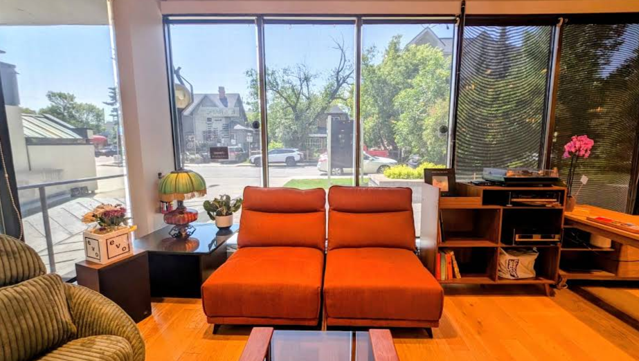 This image shows the waiting area or lounge of Fm Hair and Esthetics which is very comfortable and welcoming featuring three sofa style chairs and plenty of books to read while waiting