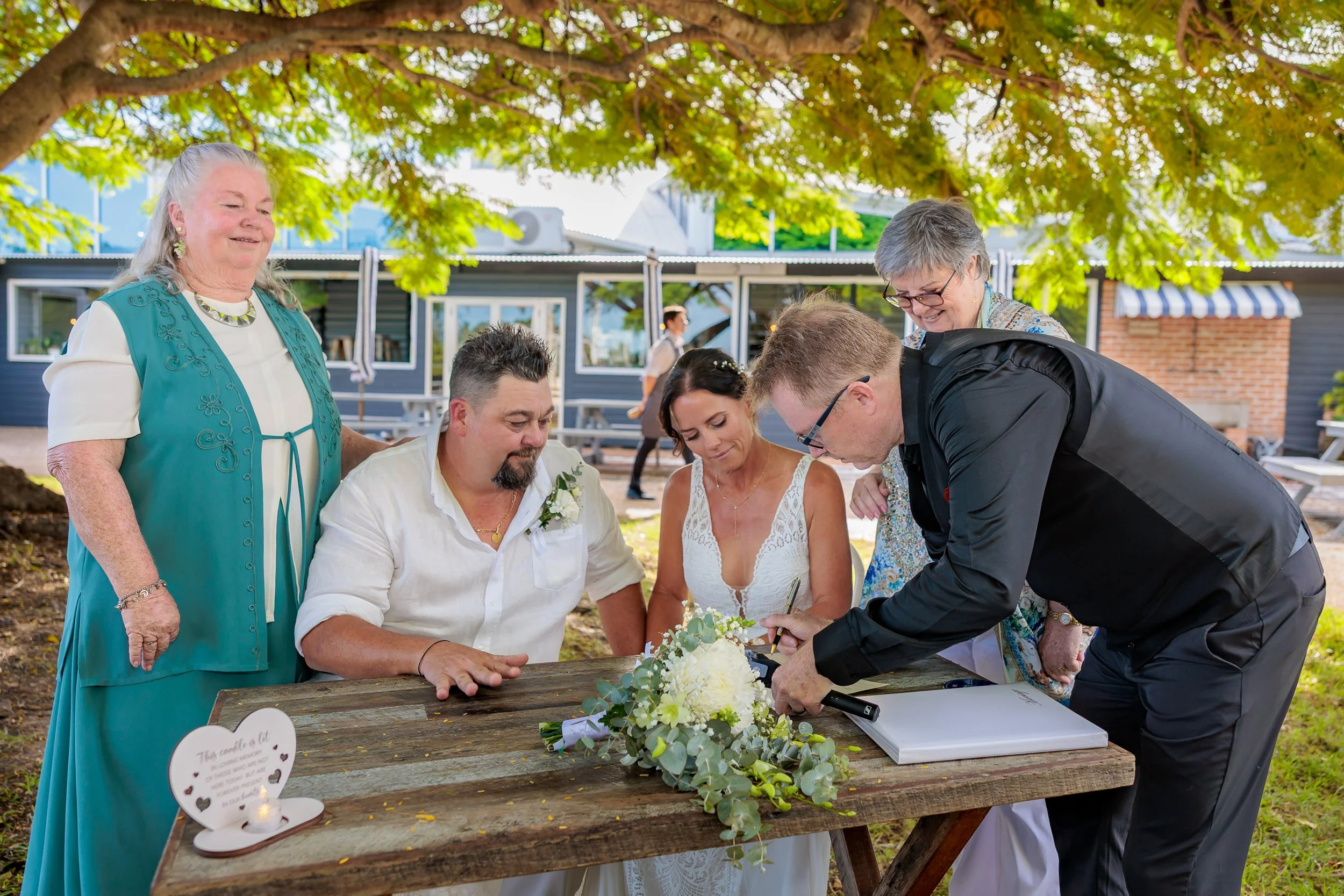 Newlyweds signing the official marriage certificate with Celebrant Glenn Ritchie in Brisbane.