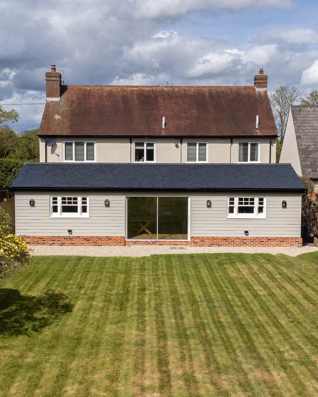 From first impressions to garden views, every detail of this Dedham transformation was designed to elevate the way the home looks, feels and functions.

At the front, a bespoke oak porch, handcrafted front door and timber garage doors have given the 