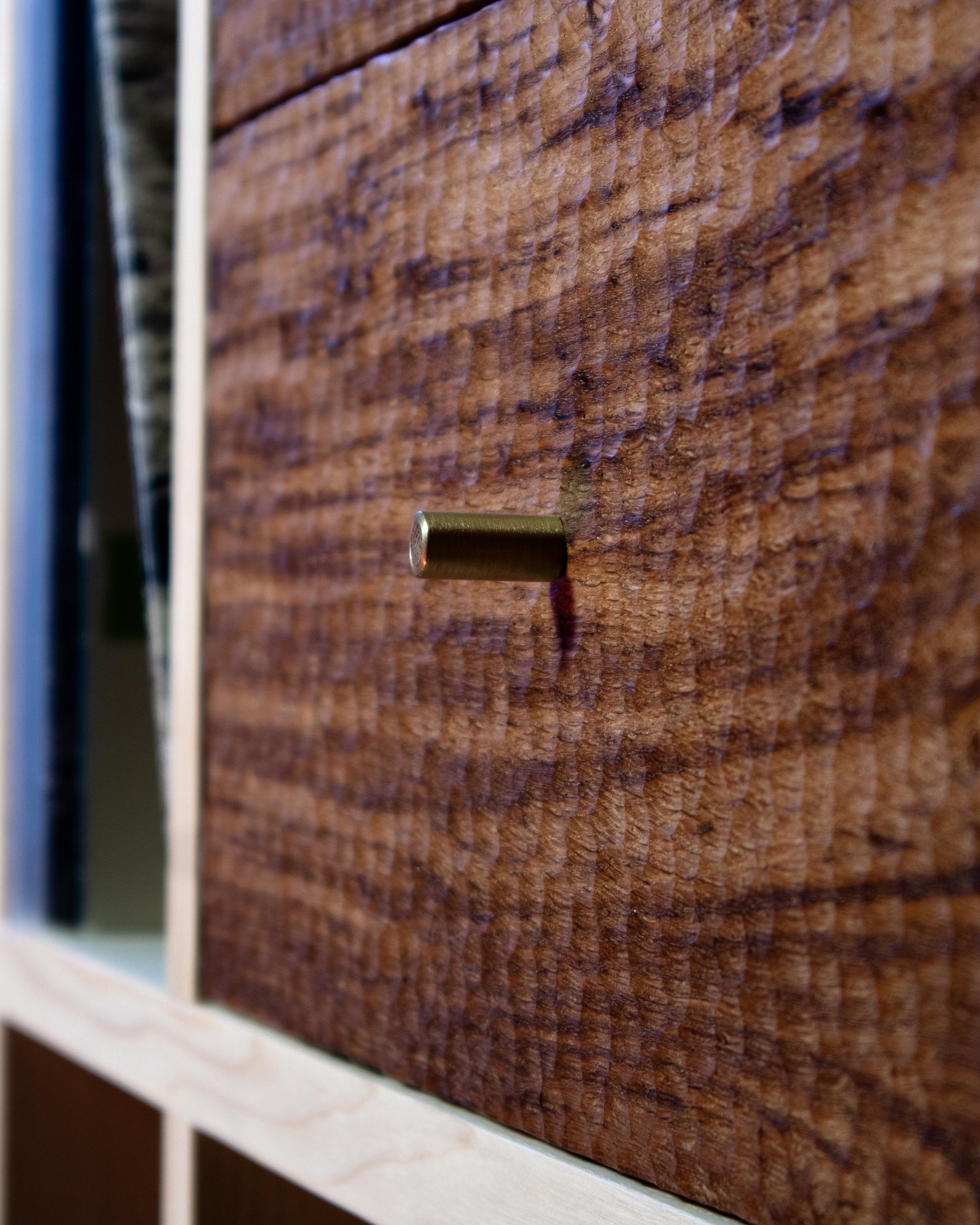 Detail of chip-carved drawer fronts and woven ash laths on a handcrafted British oak and ash record cabinet