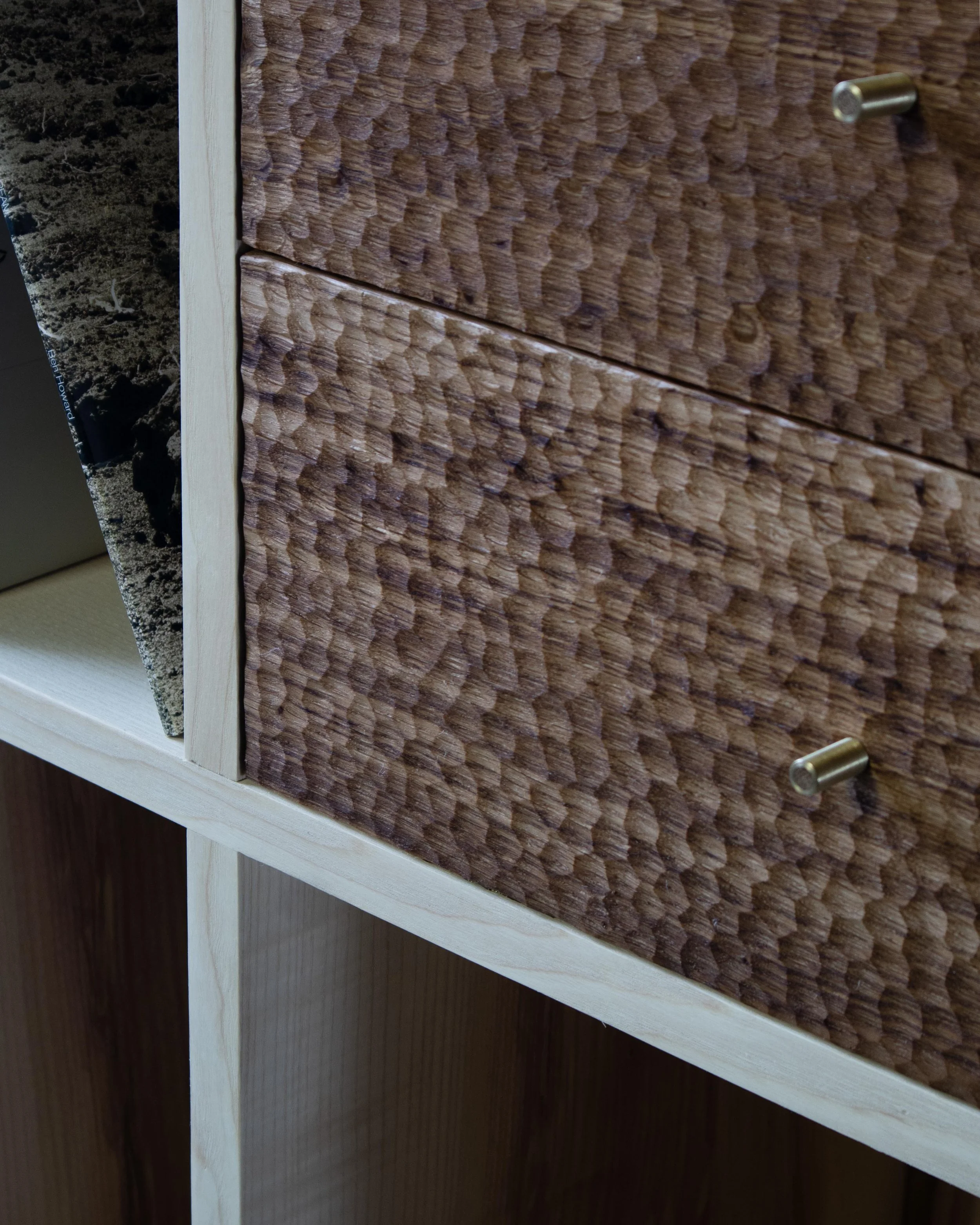 Detail of chip-carved drawer fronts and woven ash laths on a handcrafted British oak and ash record cabinet