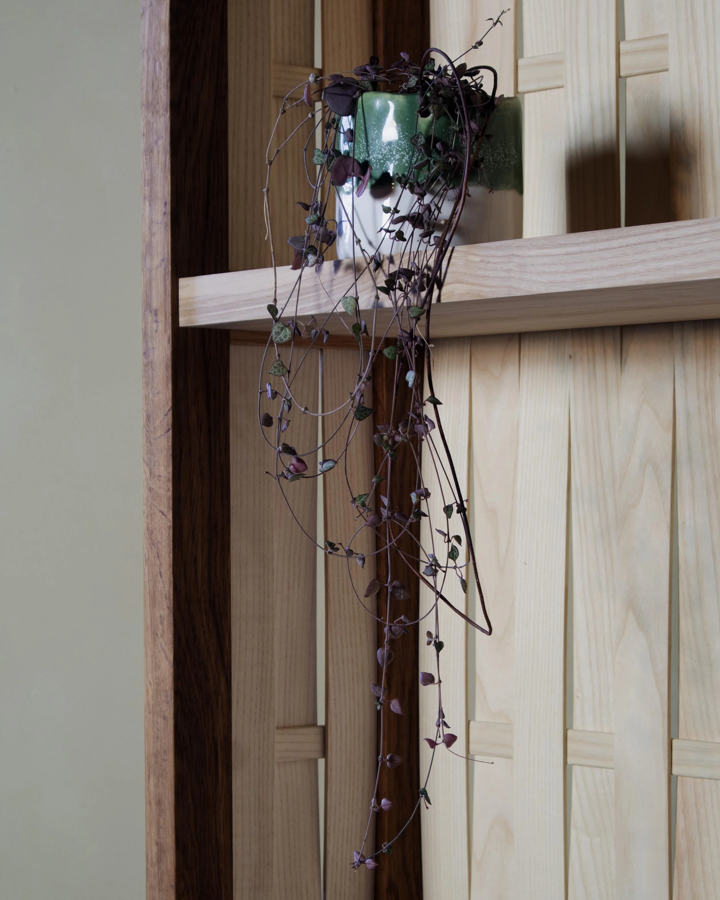 Detail of chip-carved drawer fronts and woven ash laths on a handcrafted British oak and ash record cabinet