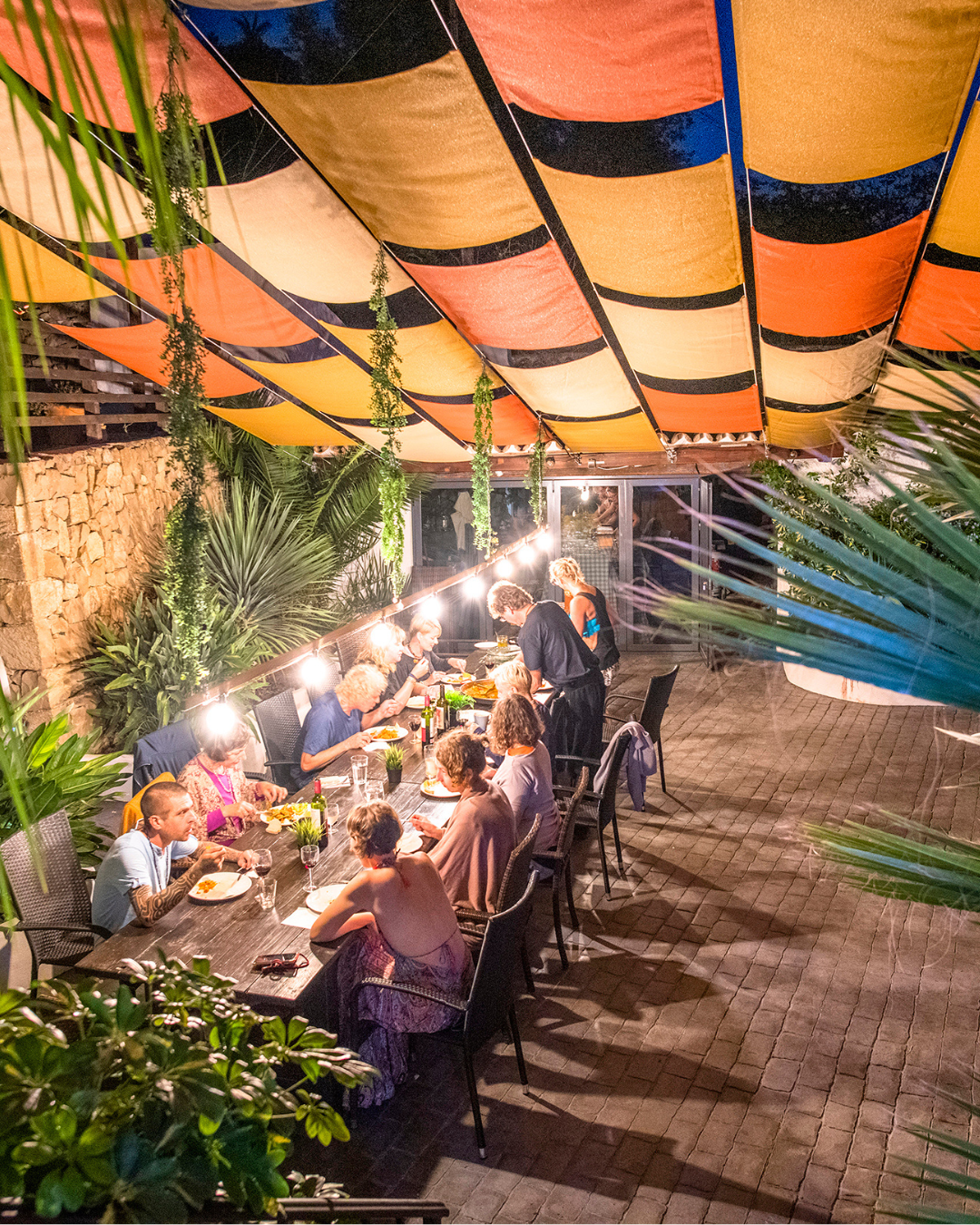 Guests enjoying communal dining at a SunKiss Yoga Retreat, connecting over soulful Spanish food