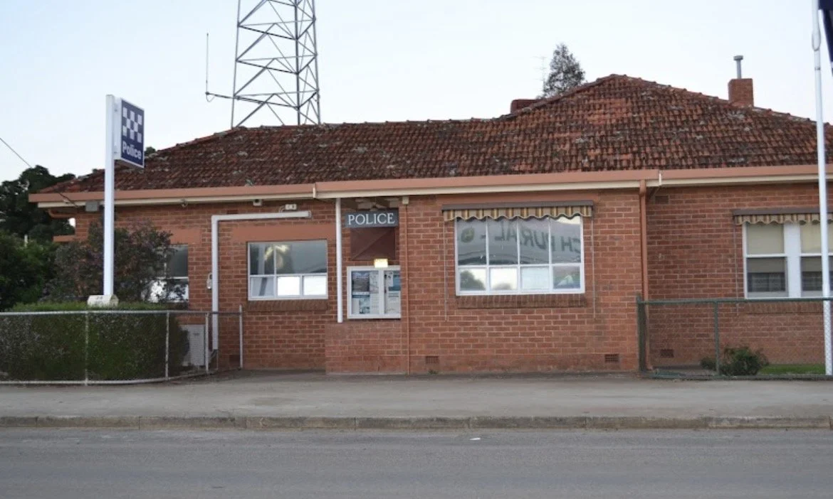 two police officers standing in yard on radio