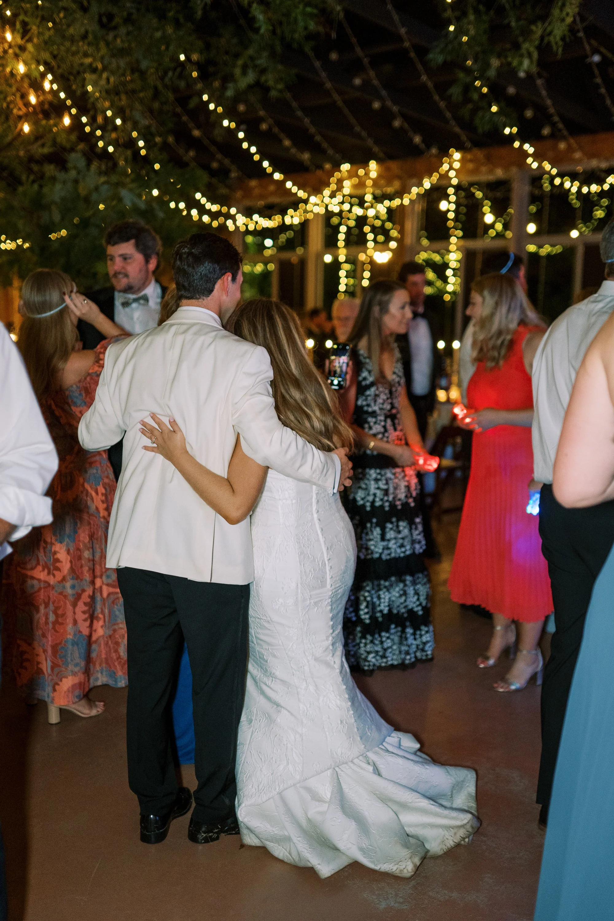 Bride and groom slow dancing among the crowd of guests
