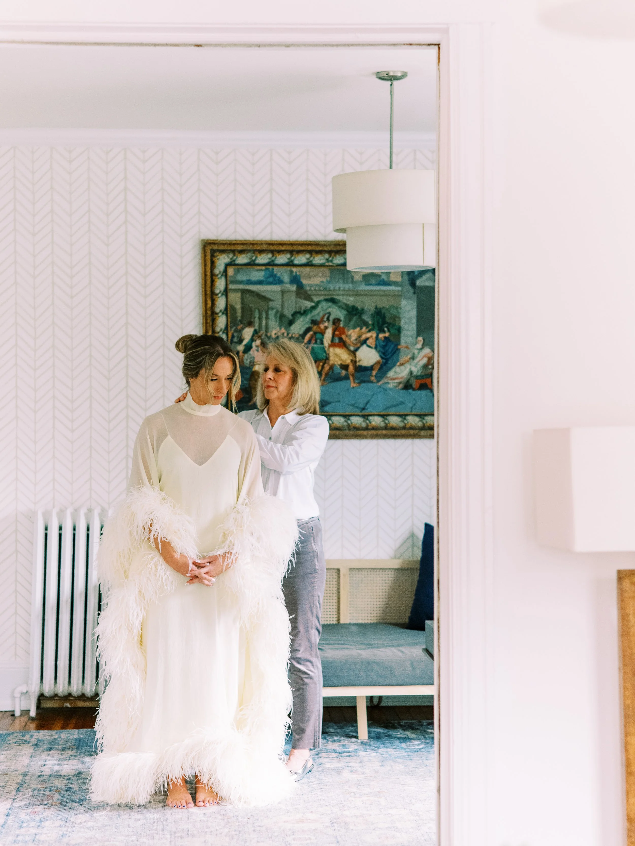 Bride finishing getting ready with help from a family member