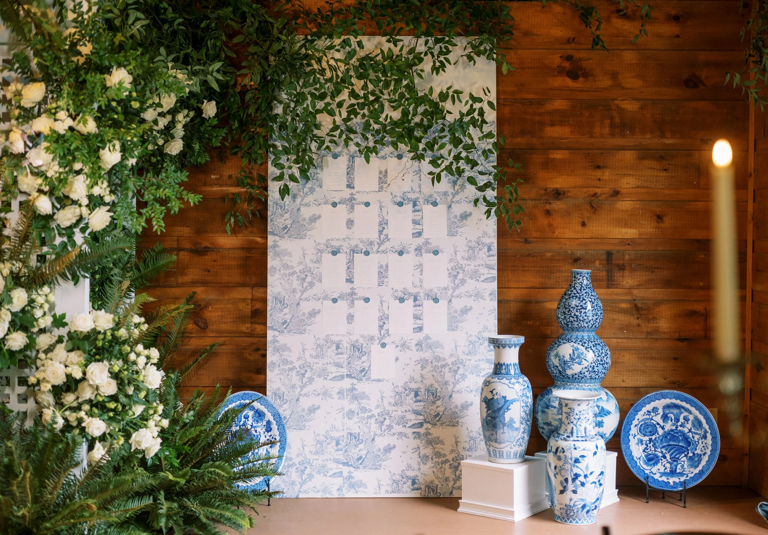 Reception decor backdrop with blue and white vases and floral arrangements