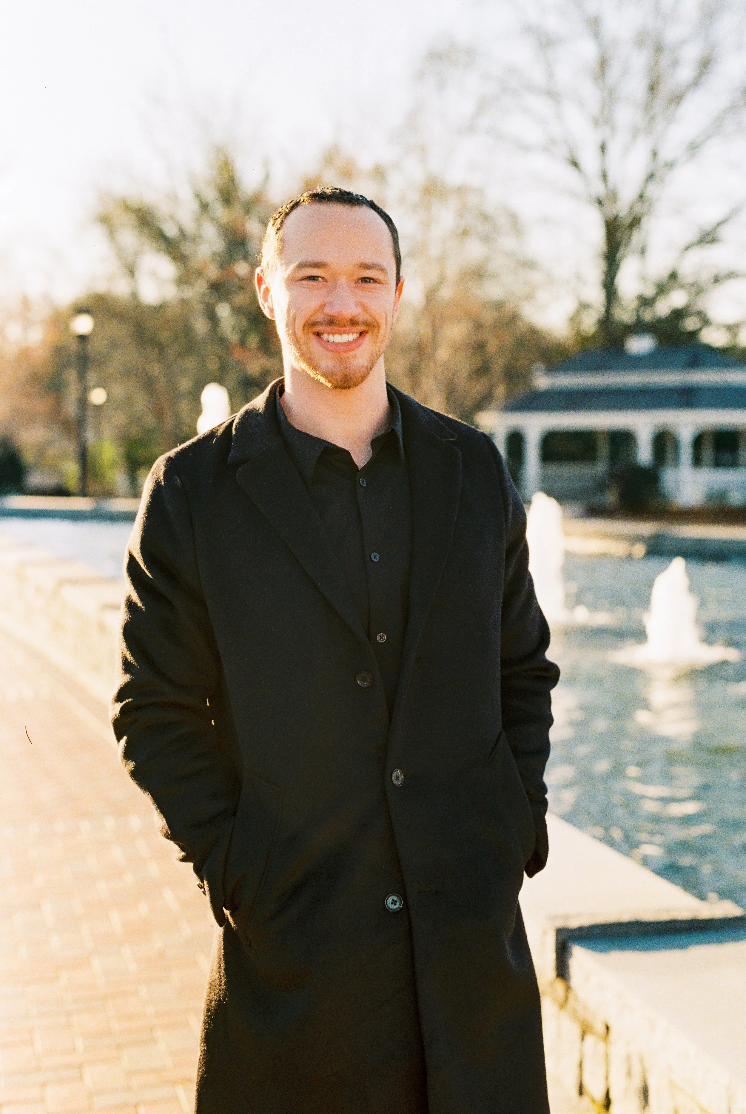 Conner poses for a solo portrait beside a fountain at golden hour in Dallas, Georgia.