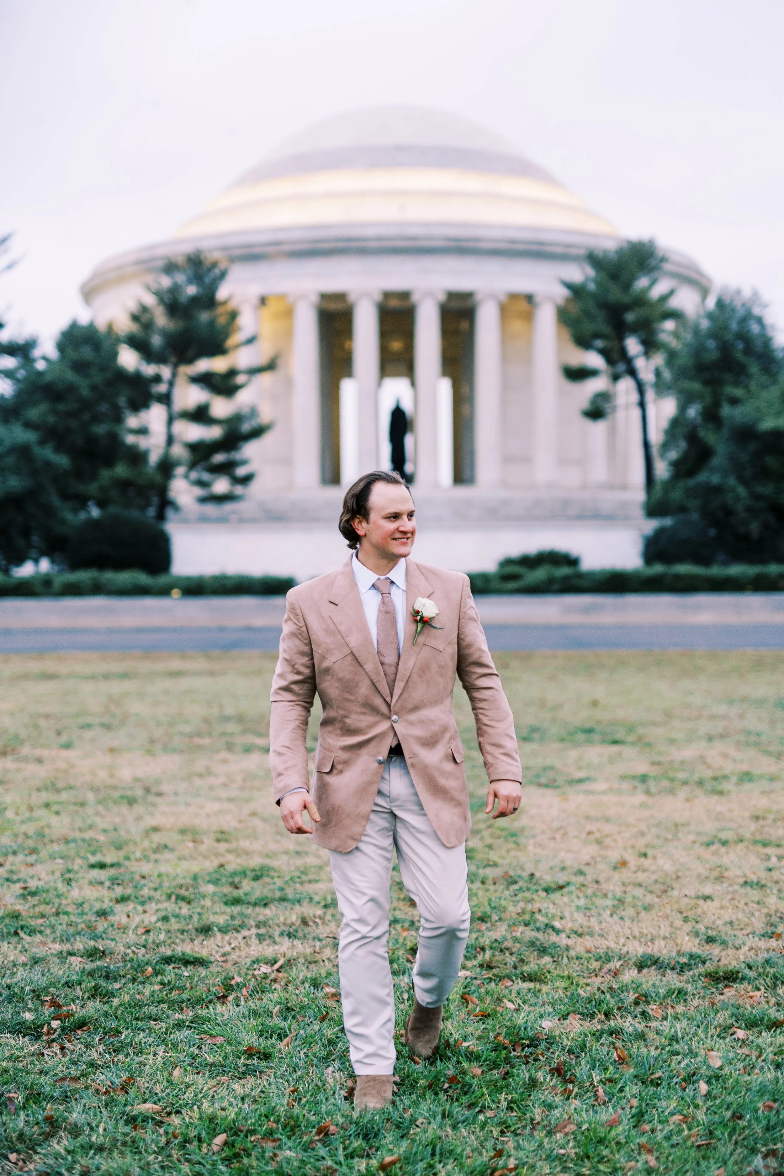 Groom walking across the lawn near the Jefferson Memorial