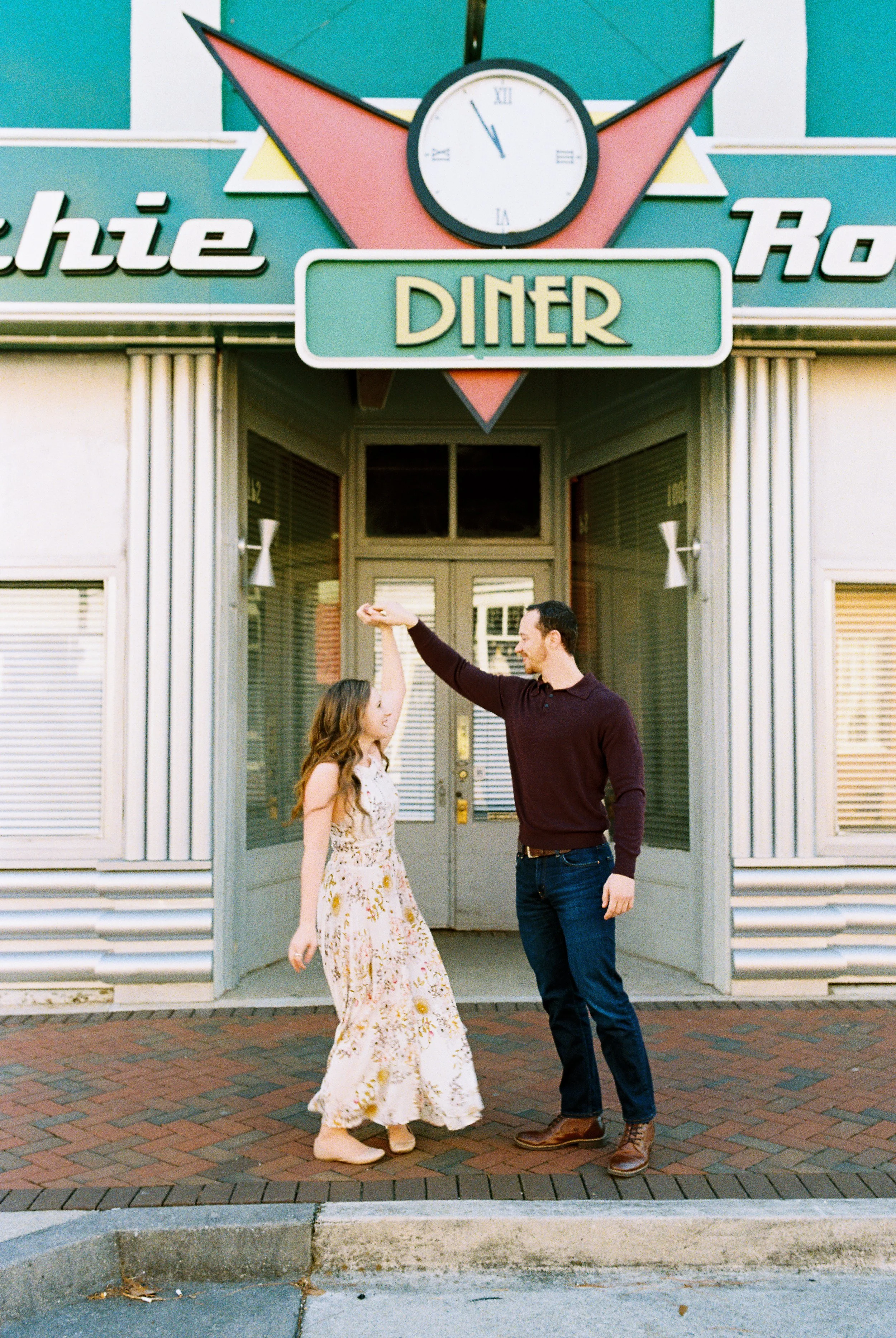 Conner twirls Maddie in front of a retro diner storefront in downtown Dallas, Georgia.