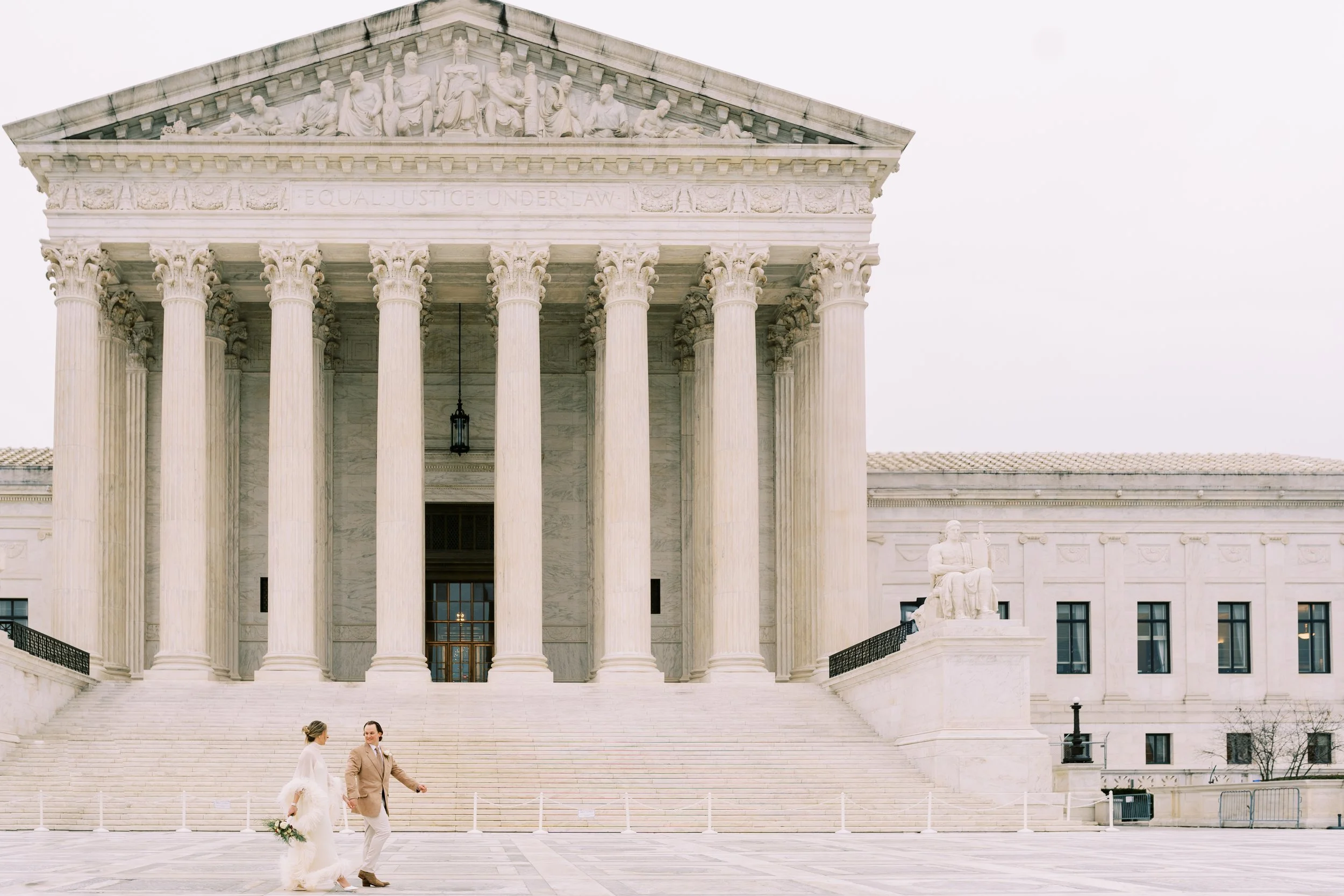 Wide shot of the bride and groom dancing in front of the grand steps of a Washington DC courthouse building