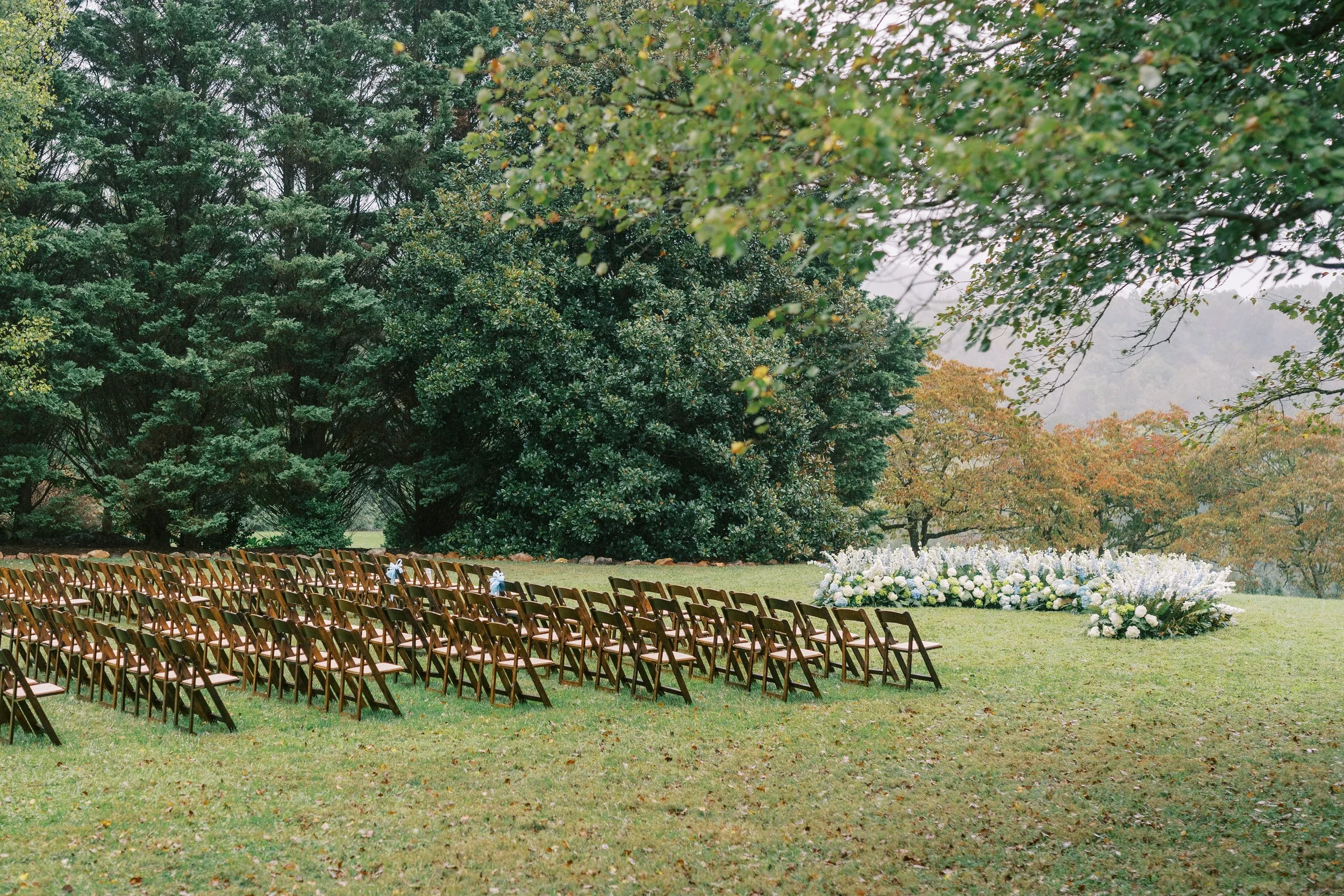 Empty ceremony chairs set up on the lawn before the wedding