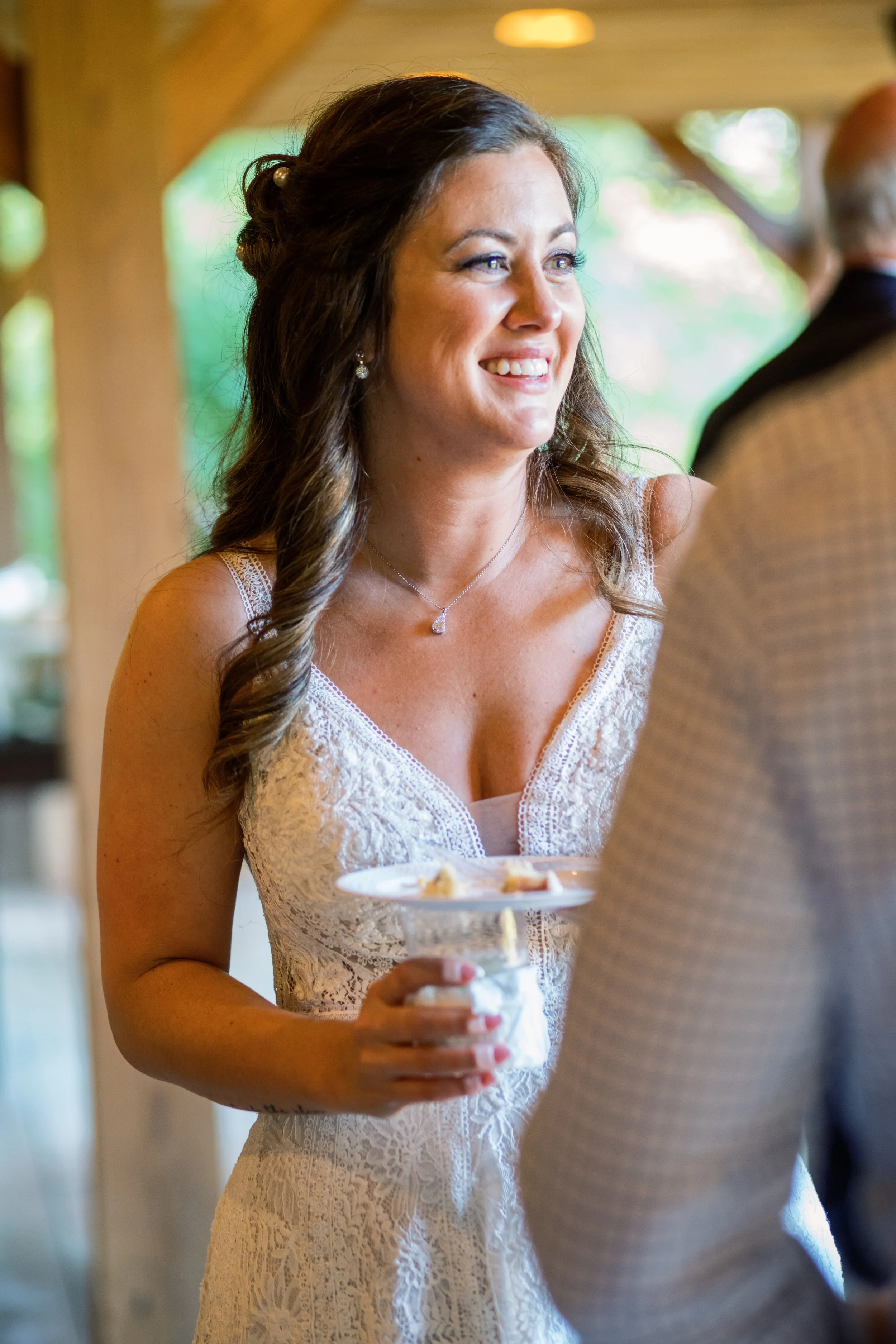 Bride laughing and smiling while holding a drink at the reception