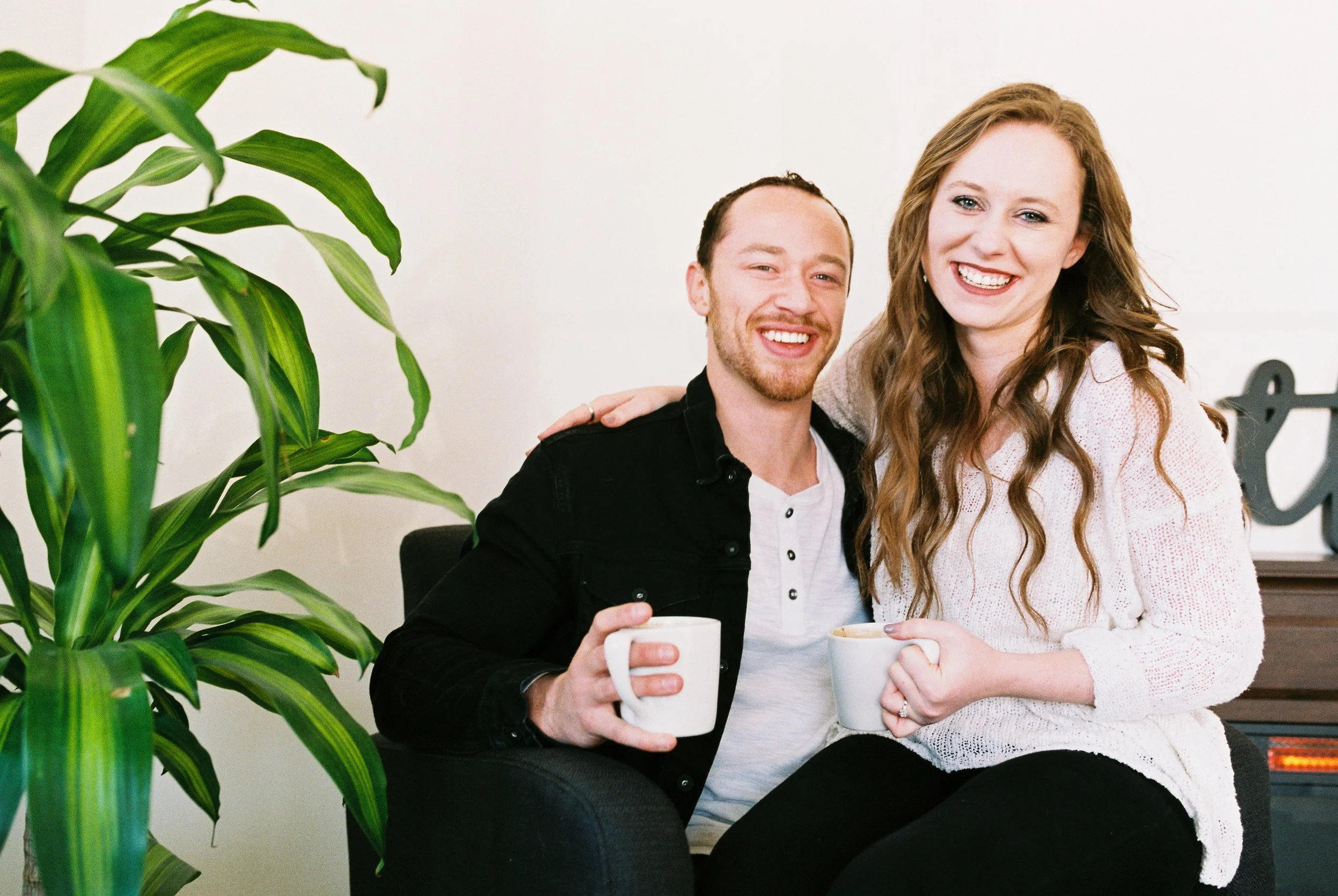 Conner and Maddie smile at the camera holding coffee mugs in a Dallas, Georgia coffee shop.