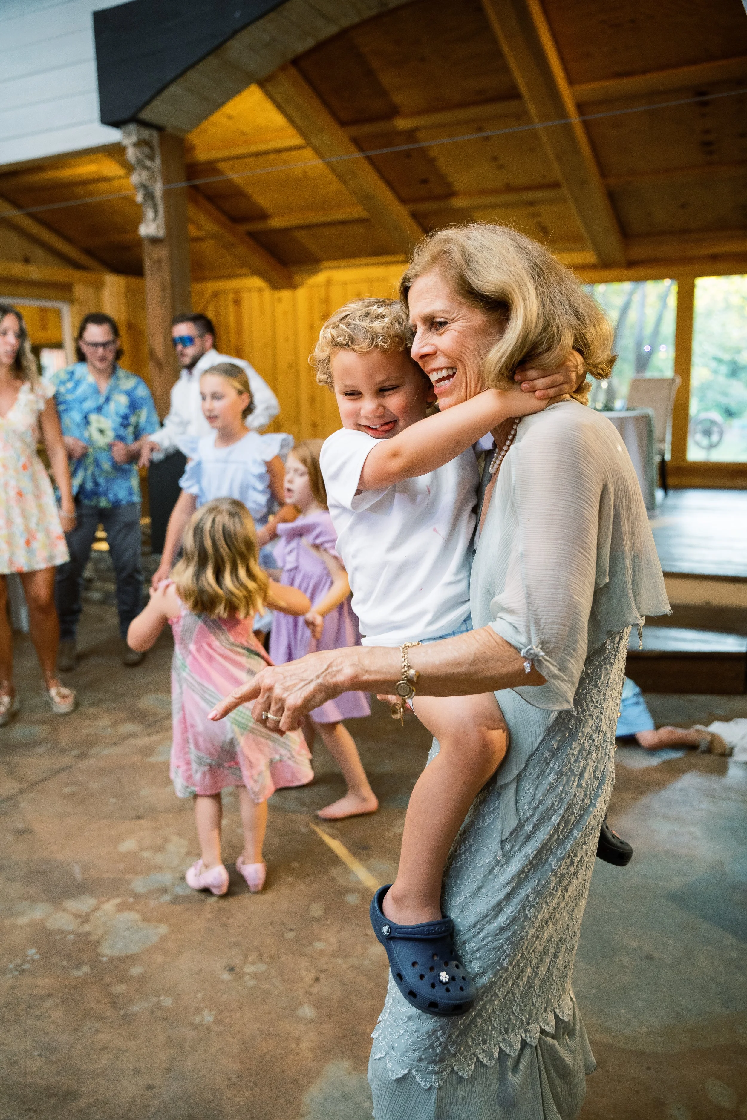 Guest bending down to talk with a young child as others gather around