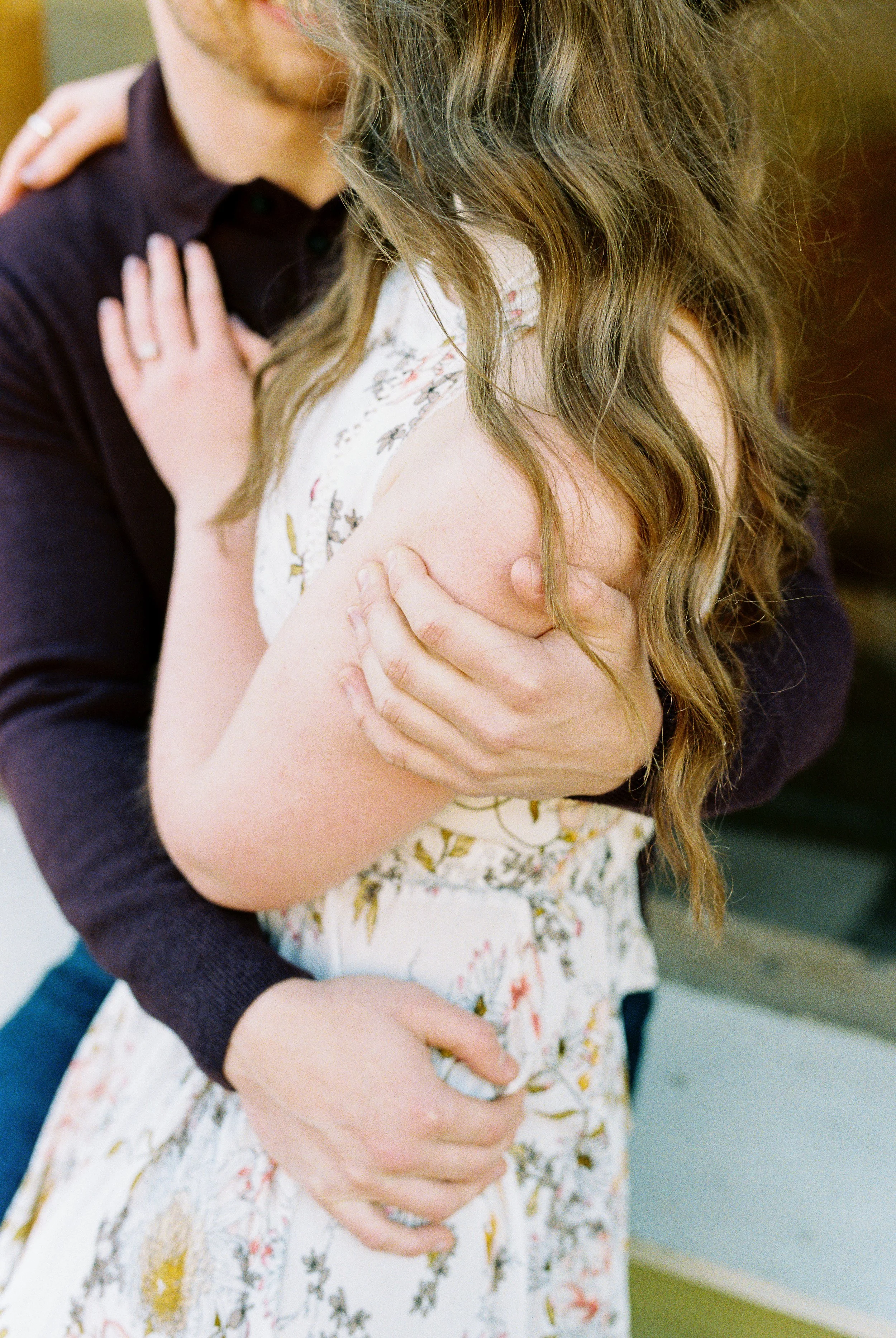A detail shot of Conner holding Maddie close, her engagement ring visible, during their Dallas, Georgia engagement session.