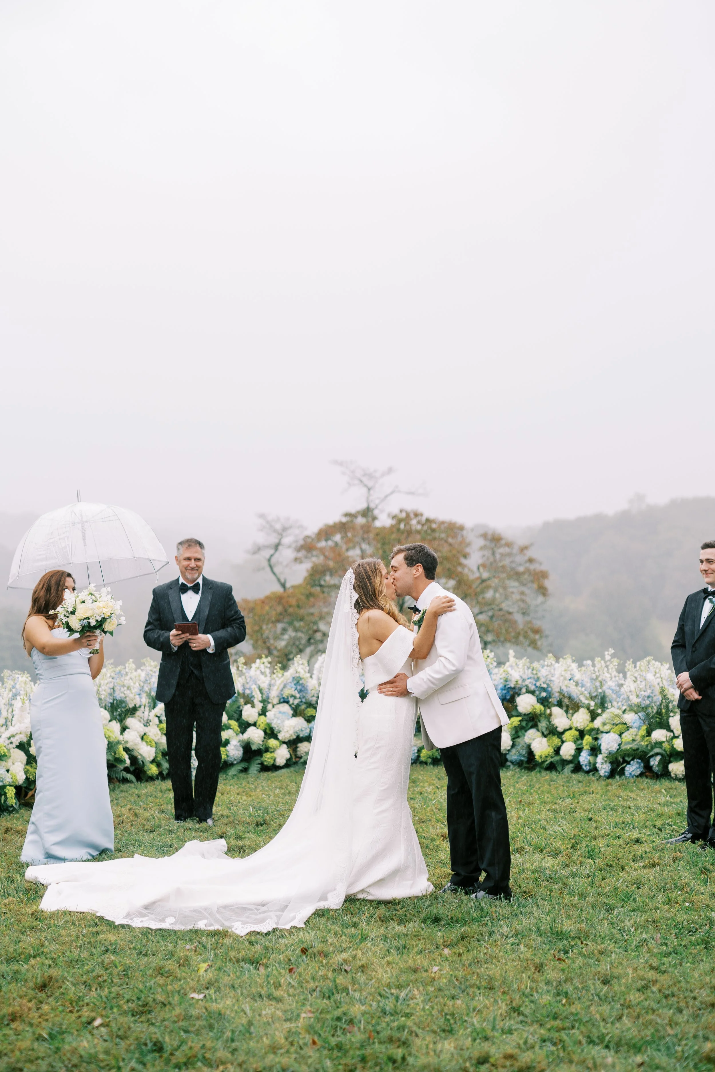 Officiant leading the couple's vows in the misty field