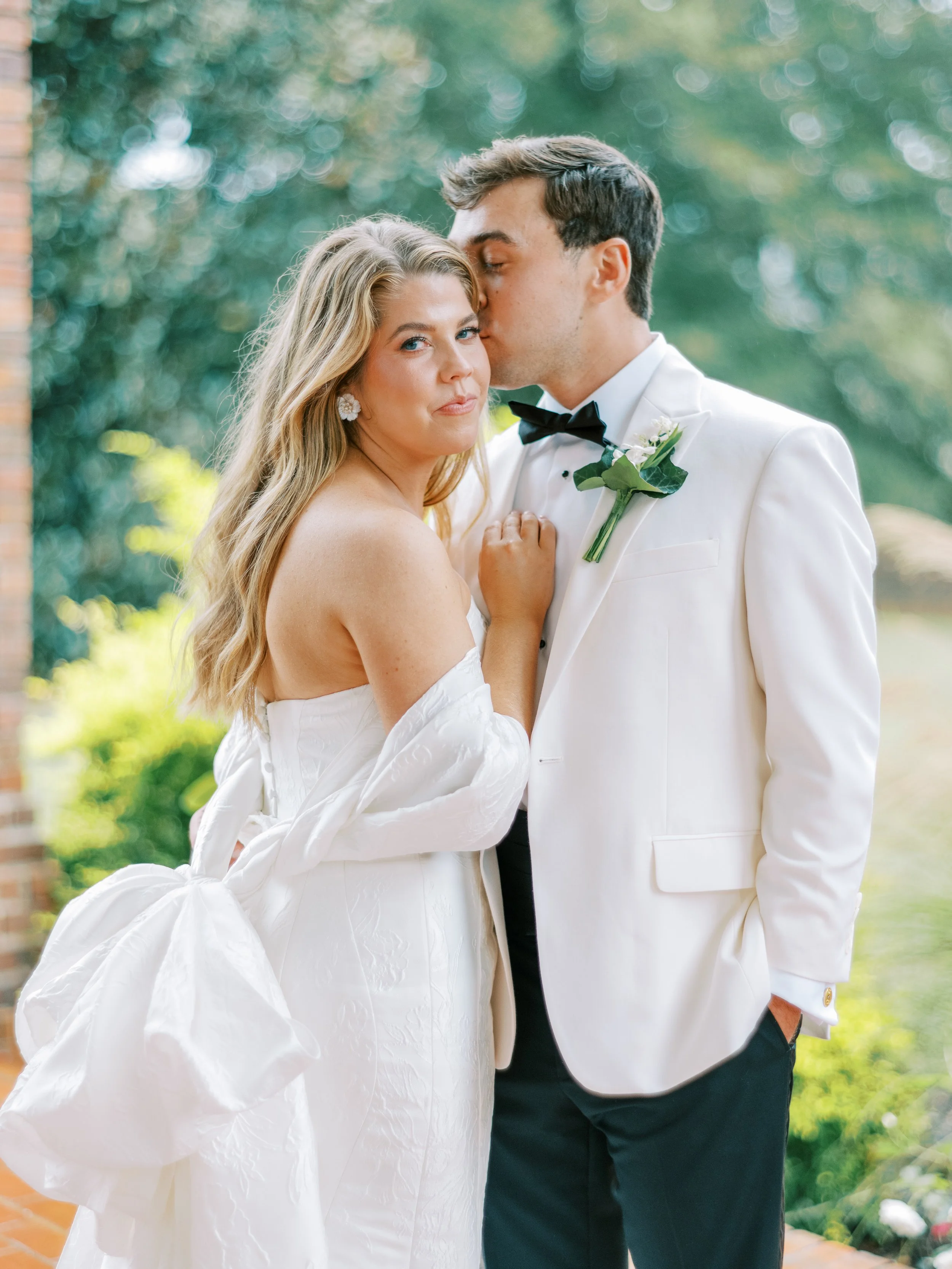 Close-up portrait of bride and groom foreheads together outdoors
