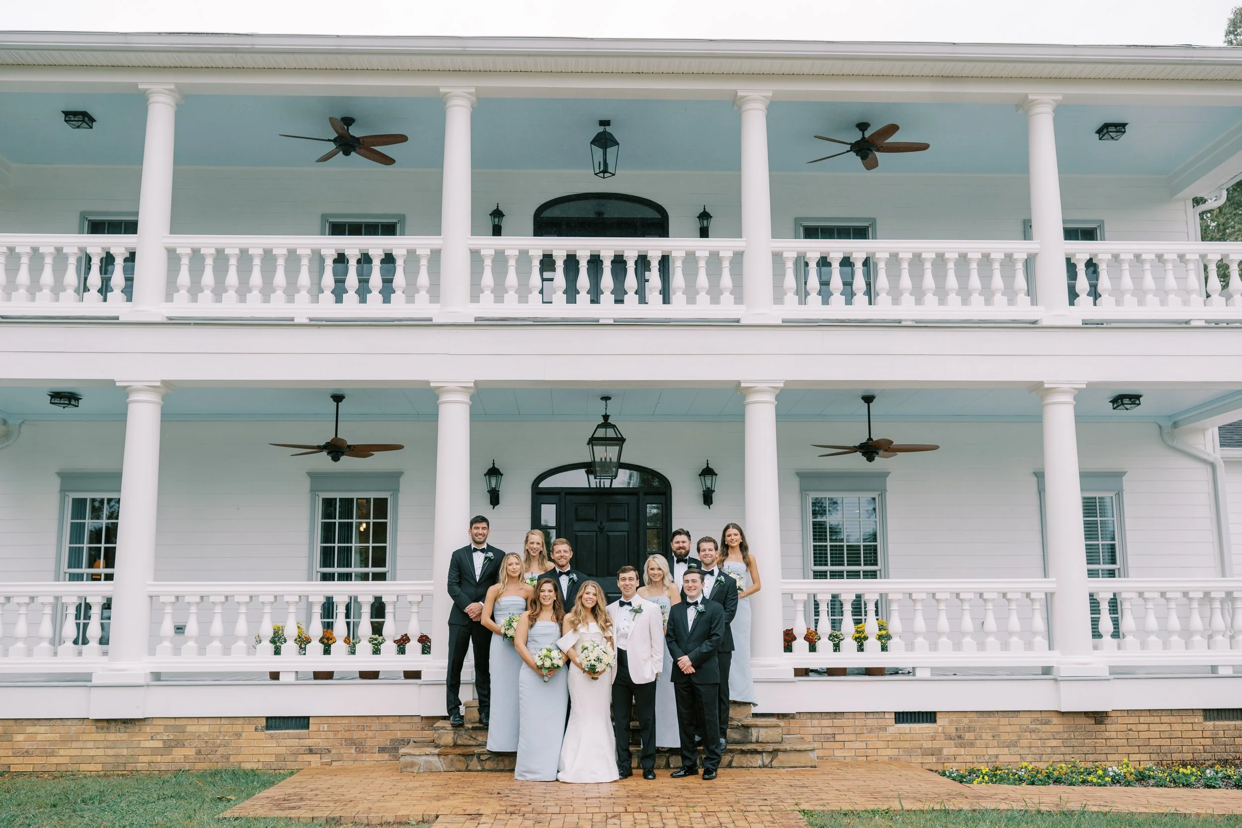 Full wedding party group portrait on the plantation house porch