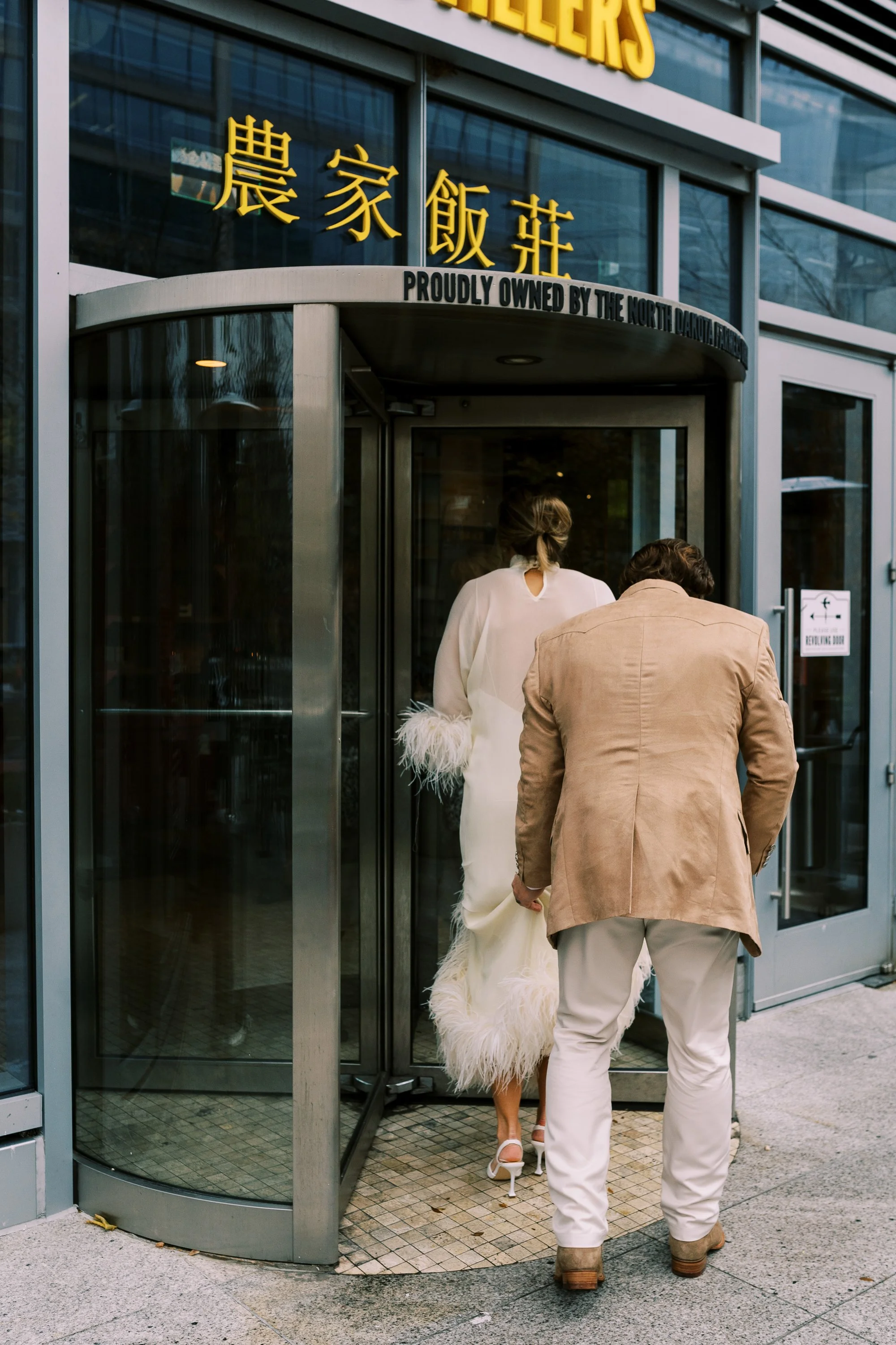 Bride and groom entering the restaurant through a revolving door