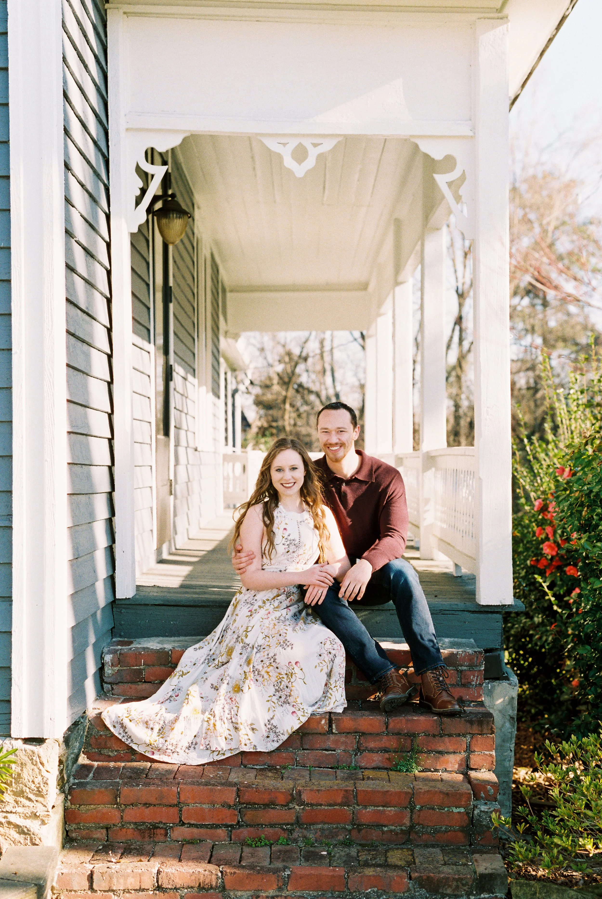 Conner and Maddie sit together on brick porch steps of a historic home in Dallas, Georgia.