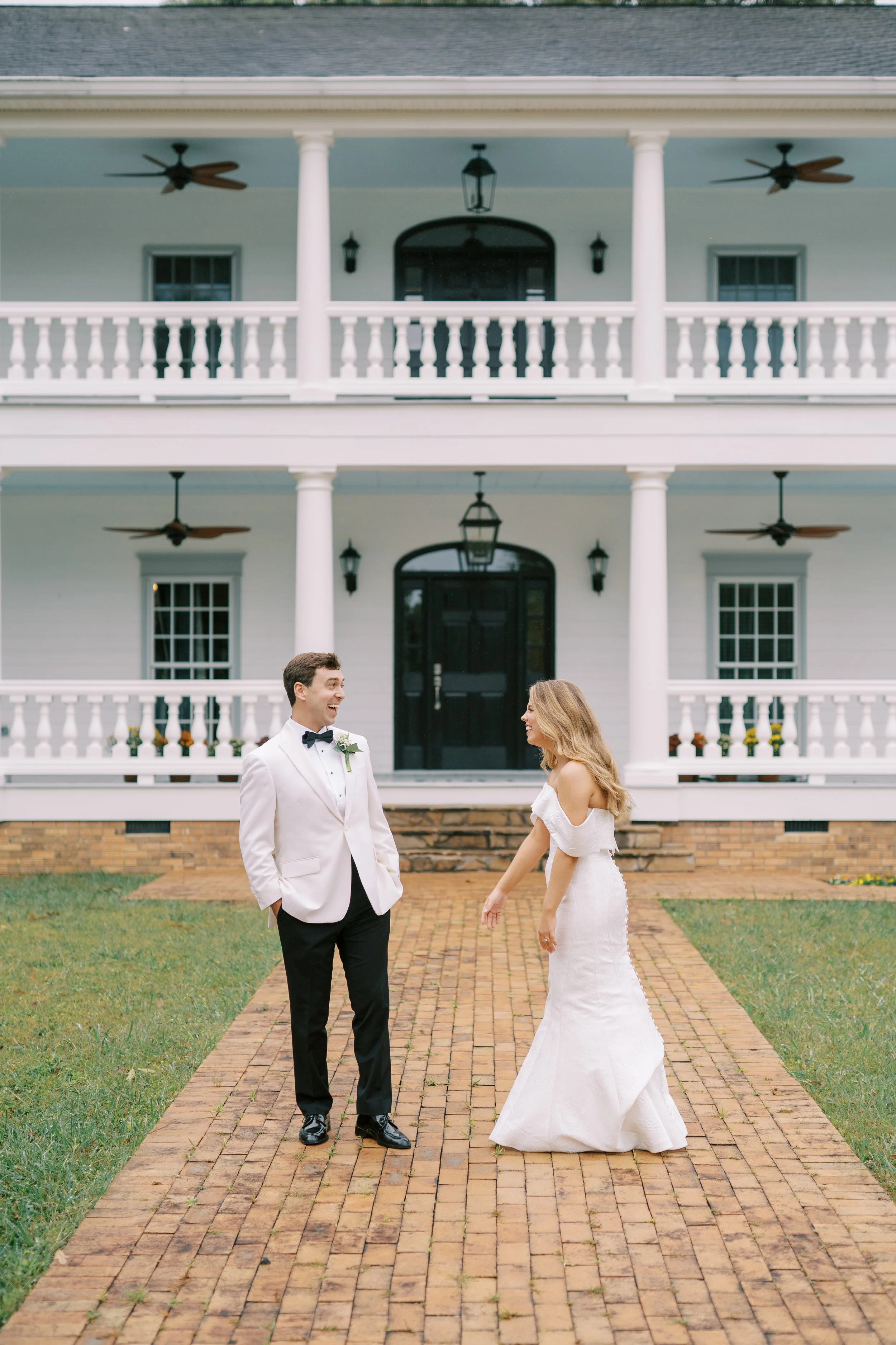 Couple walking together on the brick pathway to the plantation house