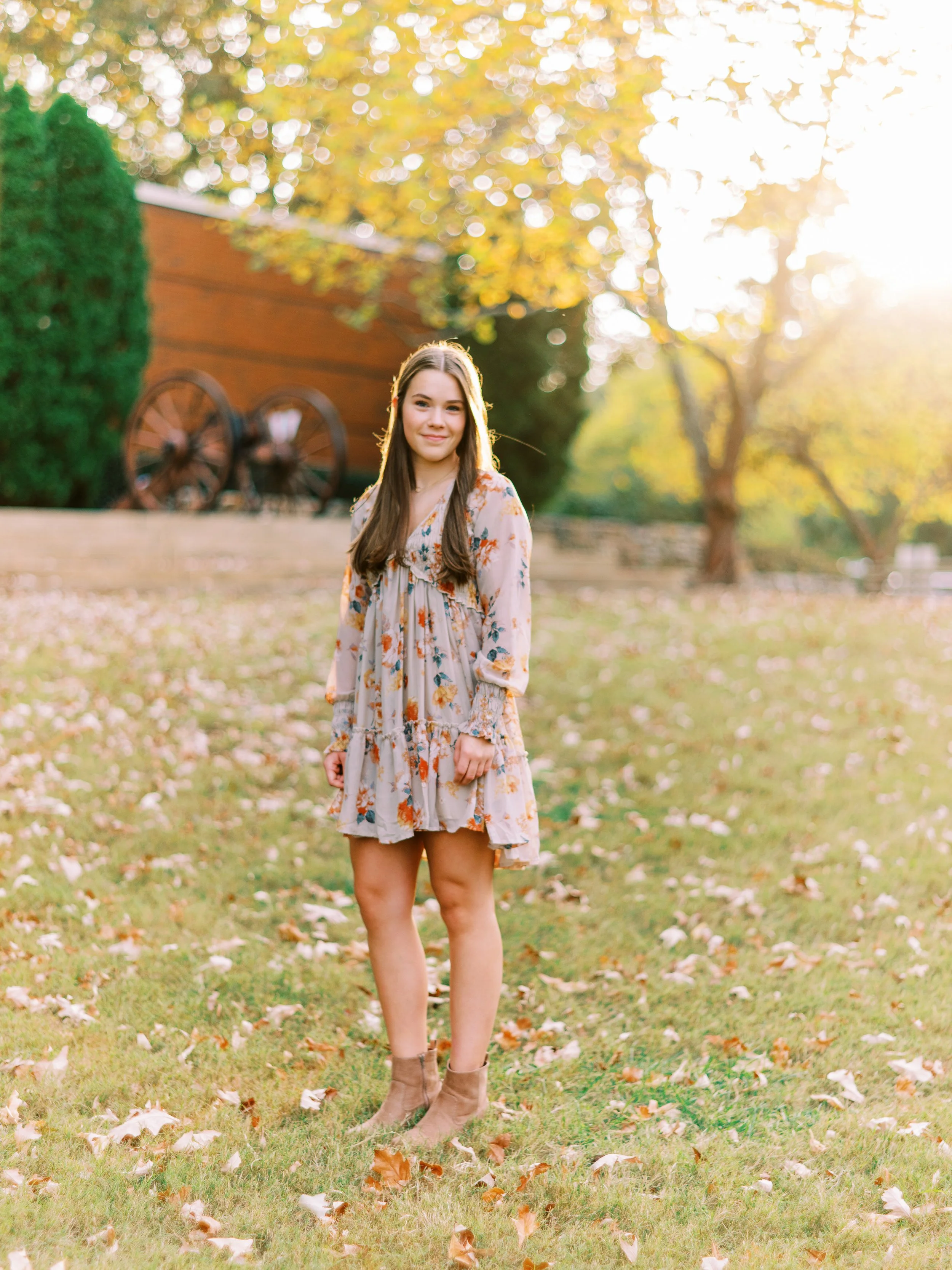 Full-length senior portrait of Hannah standing in a floral dress at golden hour at Kennesaw Mountain Battlefield Park in Kennesaw, Georgia